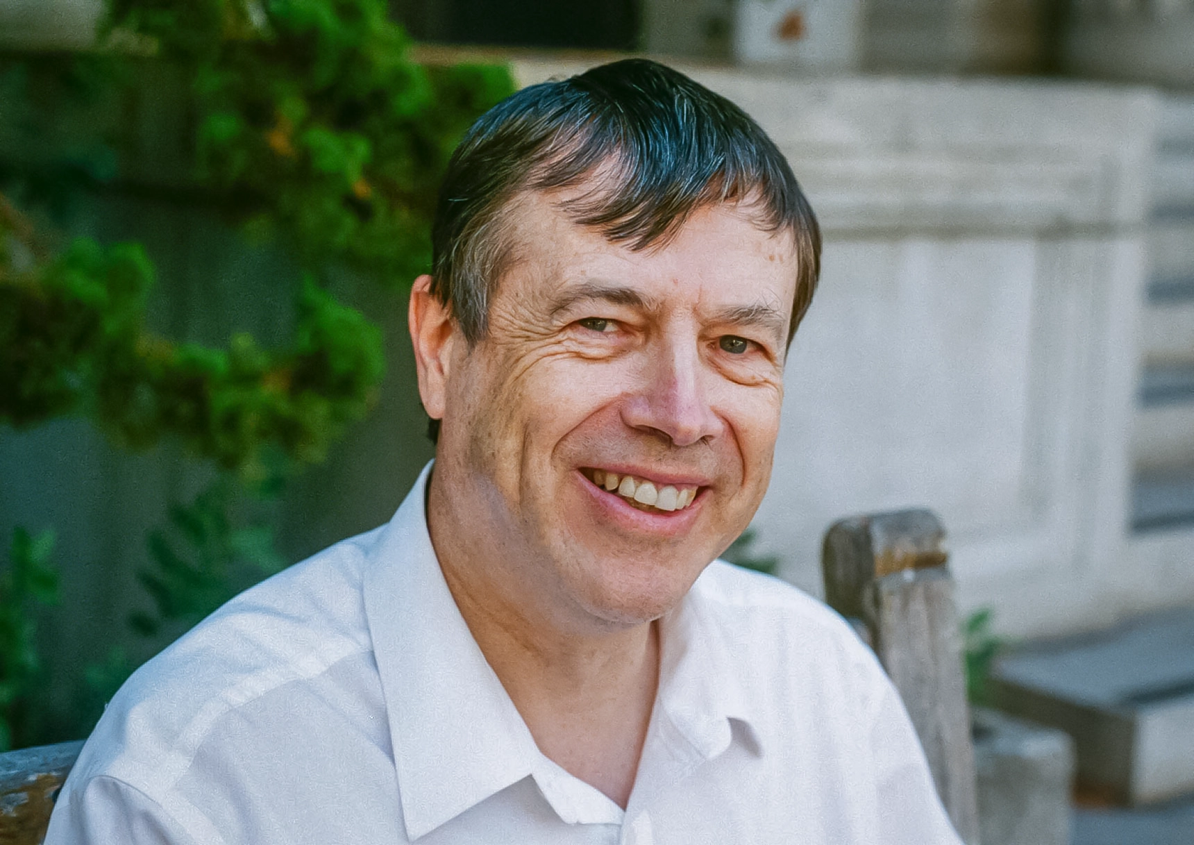 Man on a bench, smiling.