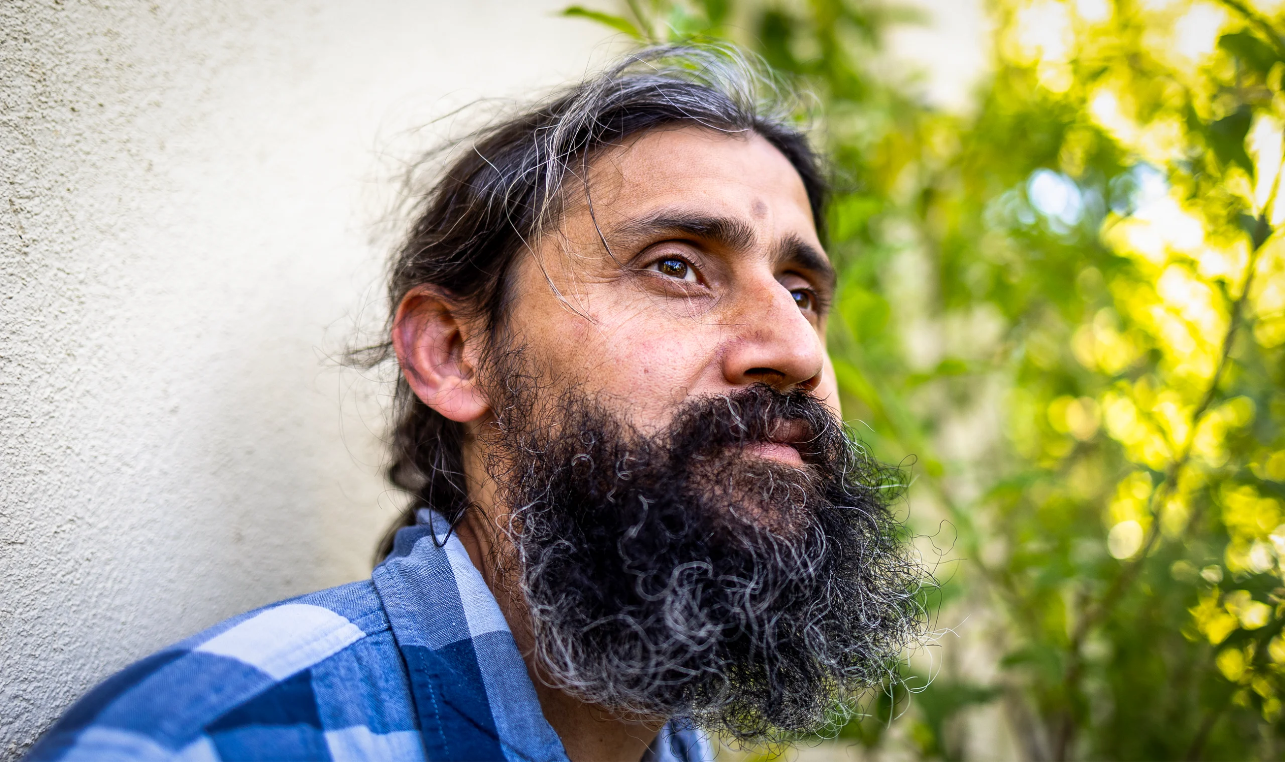 A close-up of Manu Prakash’s face: brown black hair with some gray strays, and a voluminous black beard.