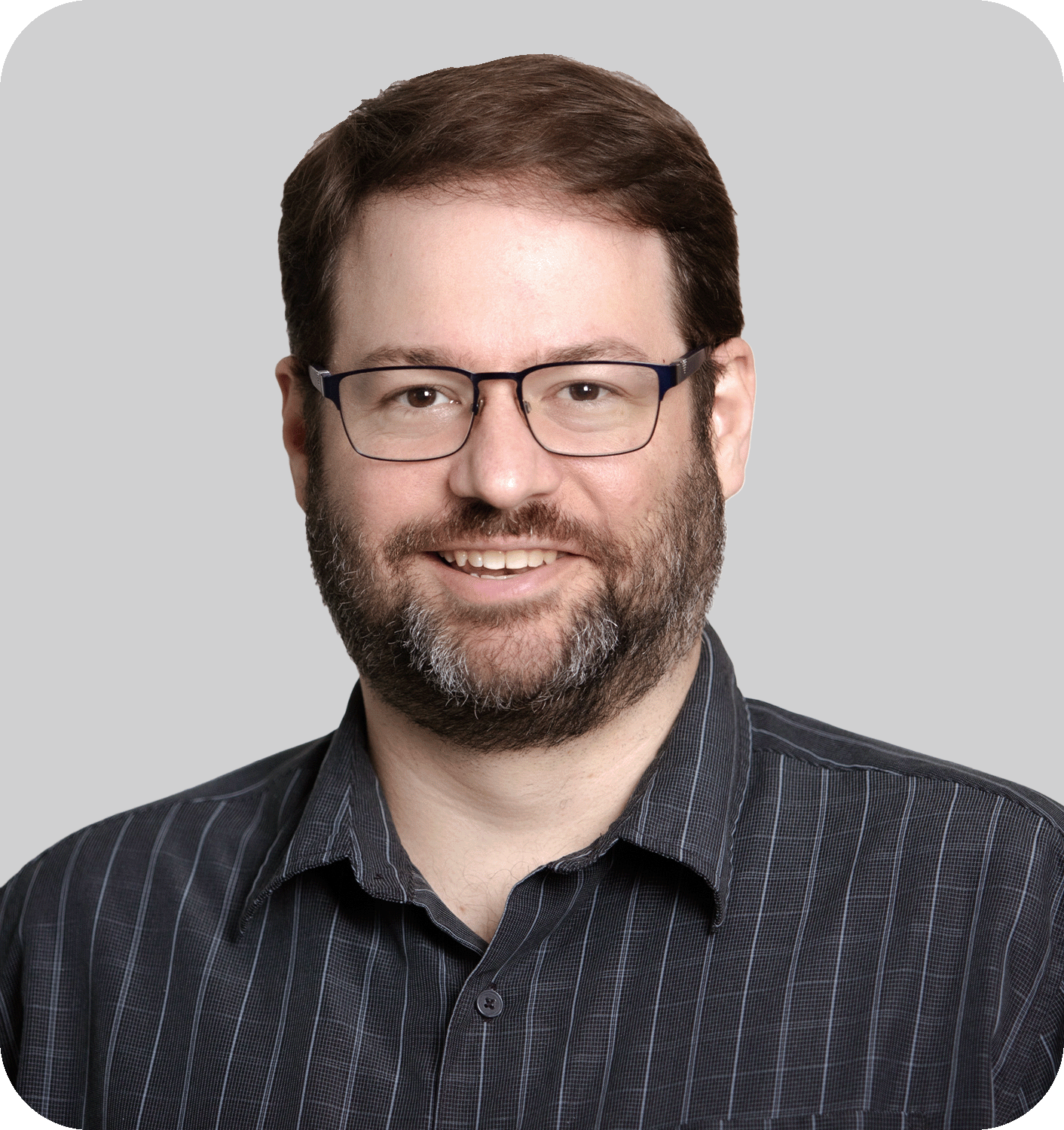 A smiling man with brown hair and glasses
