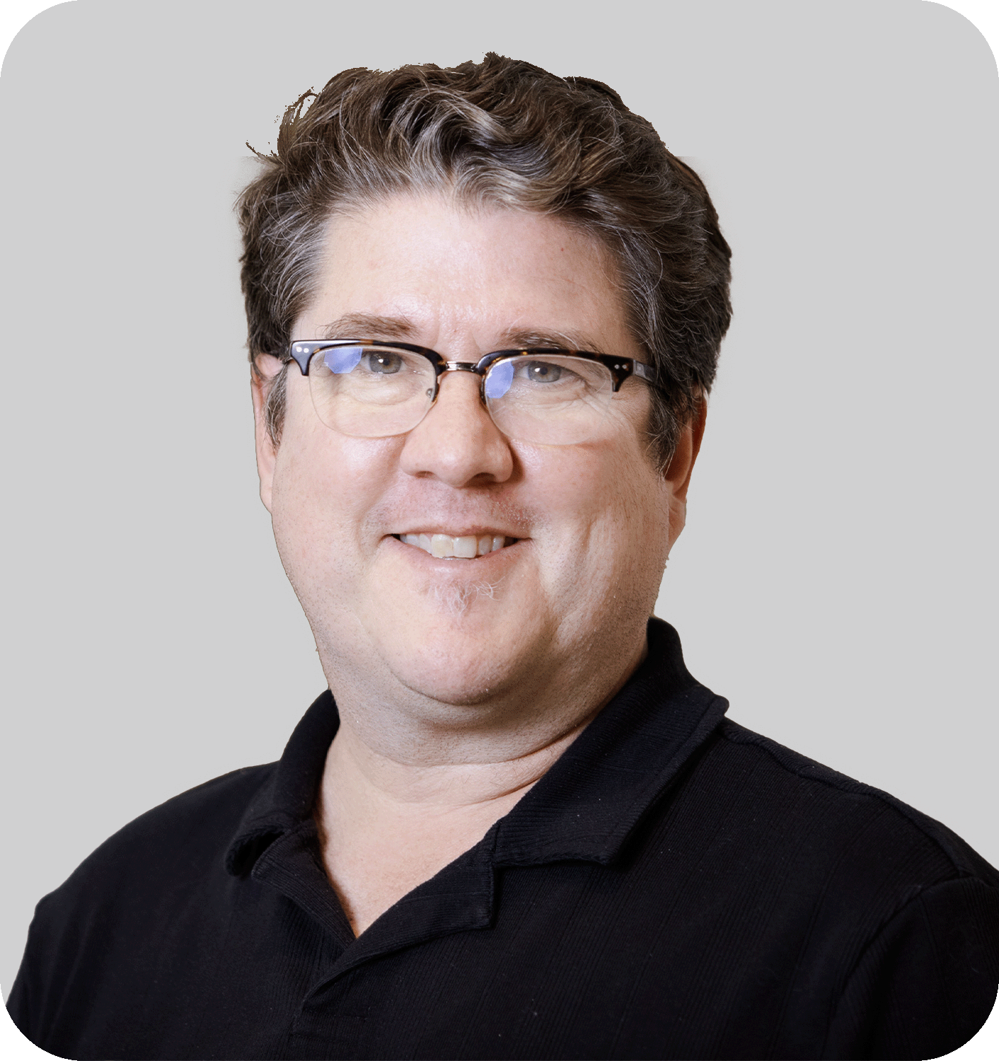 A smiling man with brown hair and glasses