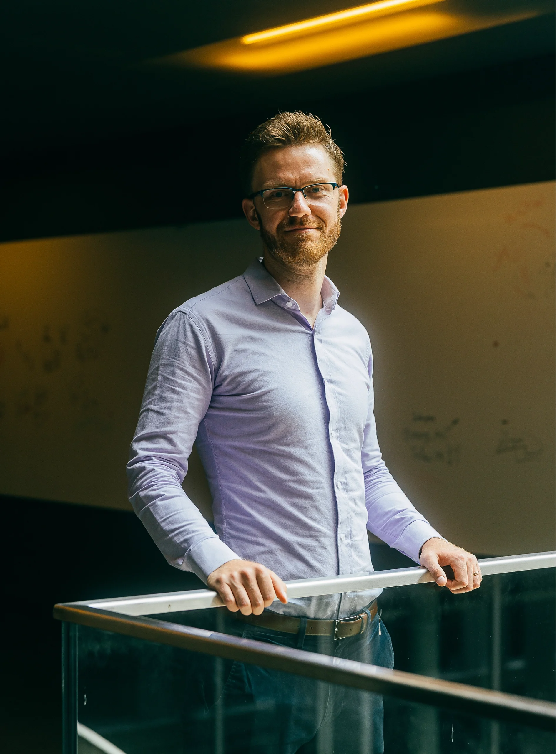 Martin Schrimpf in a purple shirt stands in front of a guardrail