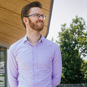 A man in glasses and a purple shirt