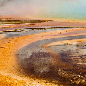 Steam billows off a colorful hot spring.