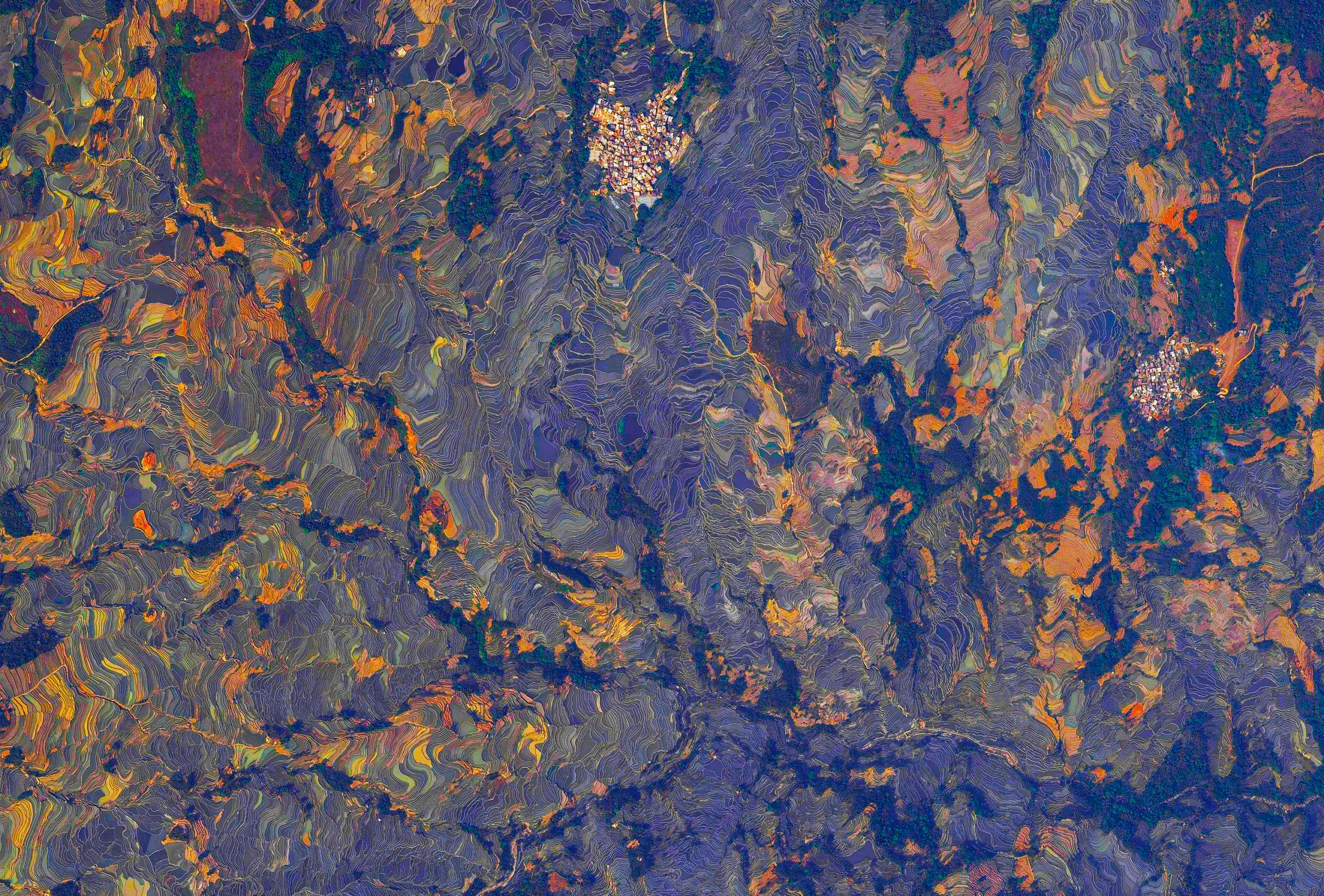 An overhead image provides a kaleidoscopic view of thousands of stepped rice paddies.