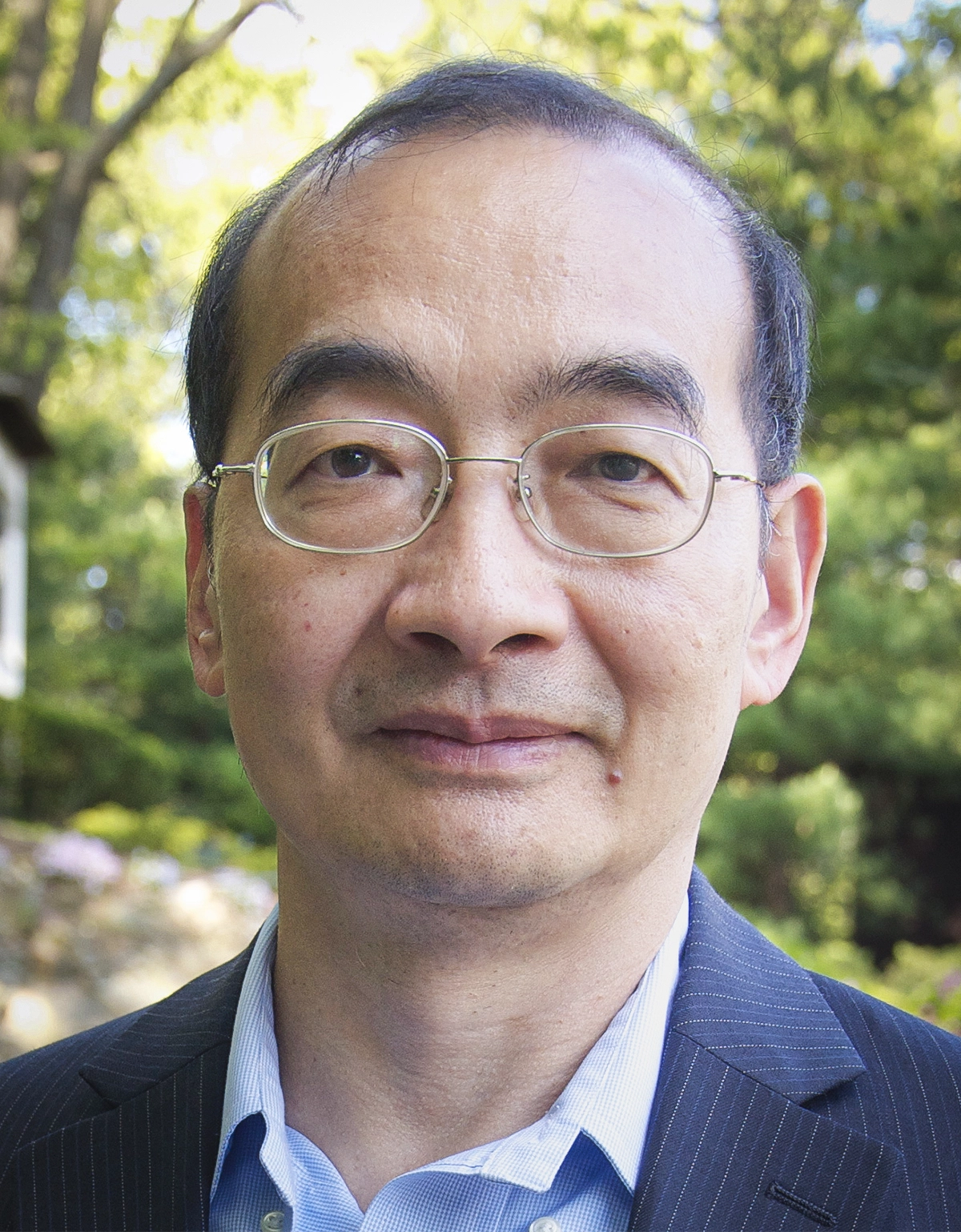 A man in glasses, a blue shirt and blue blazer