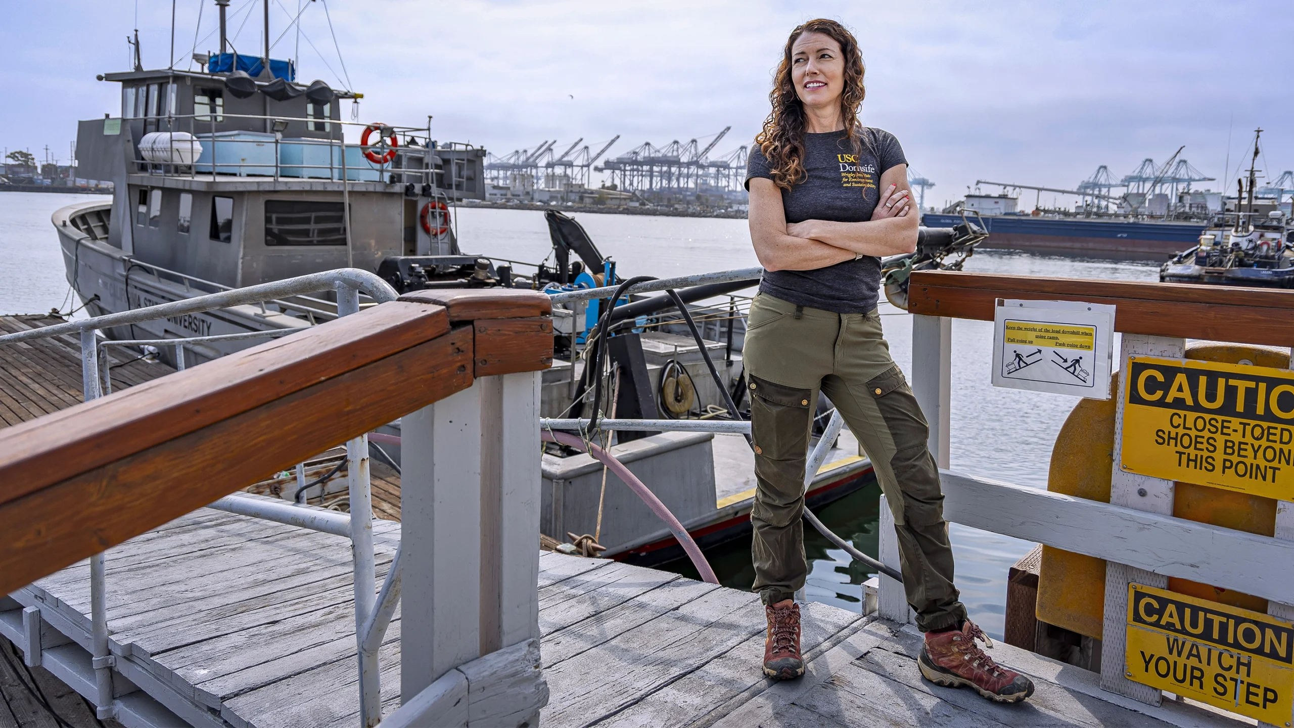 Lloyd stands on a dock in front of a research boat.