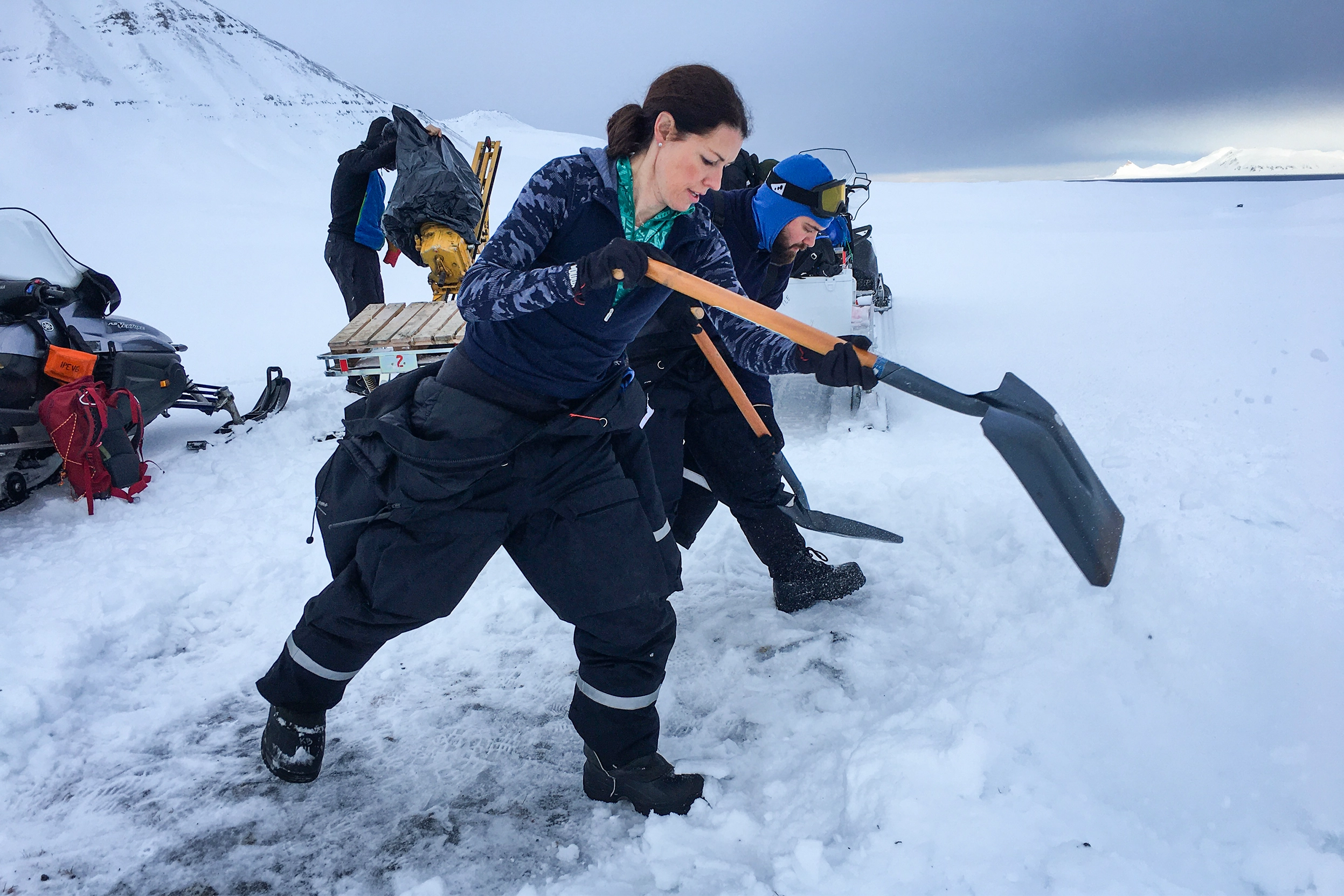 Lloyd digs into a snowbank with a shovel in a snow-covered expanse