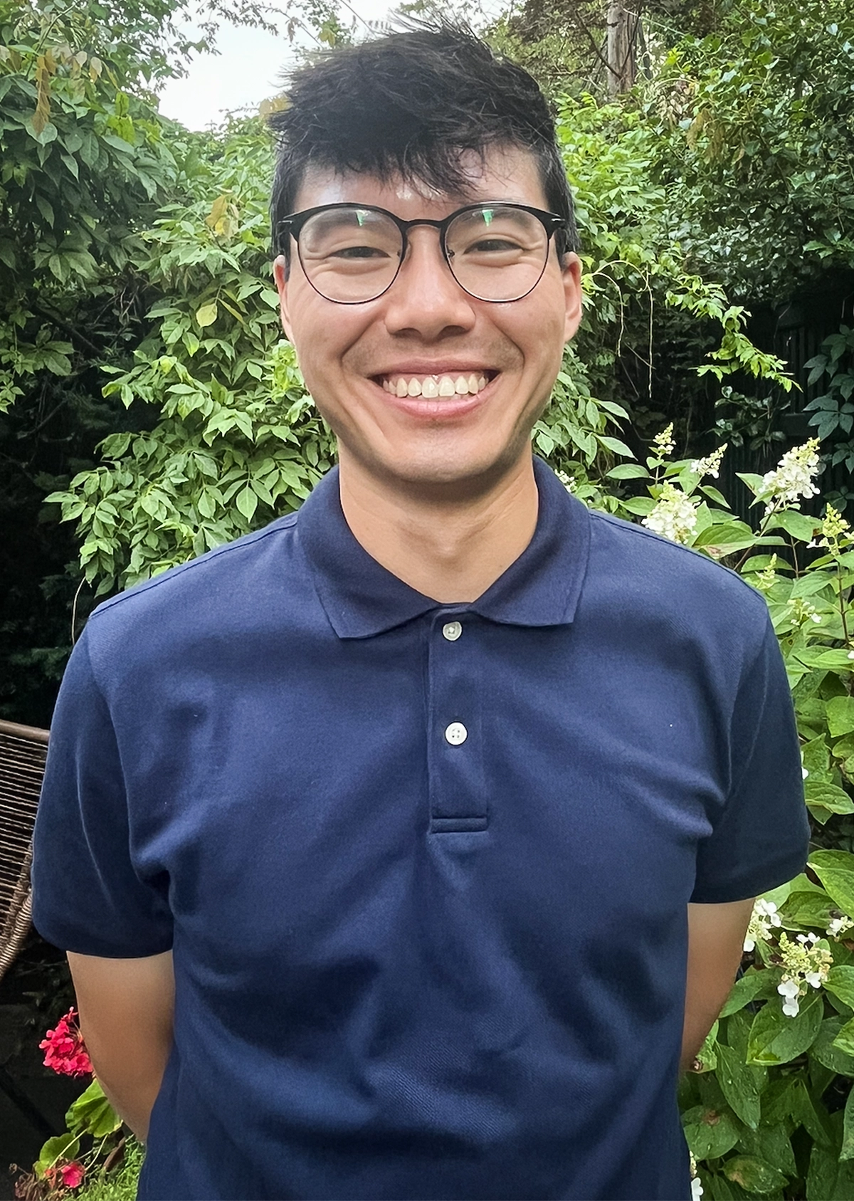 A smiling man wearing glasses and a blue shirt