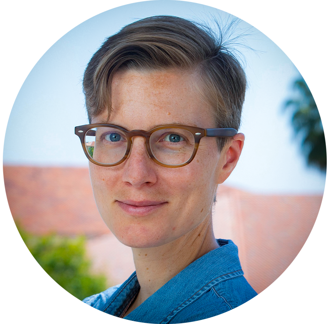 A woman with short hair and glasses smiling