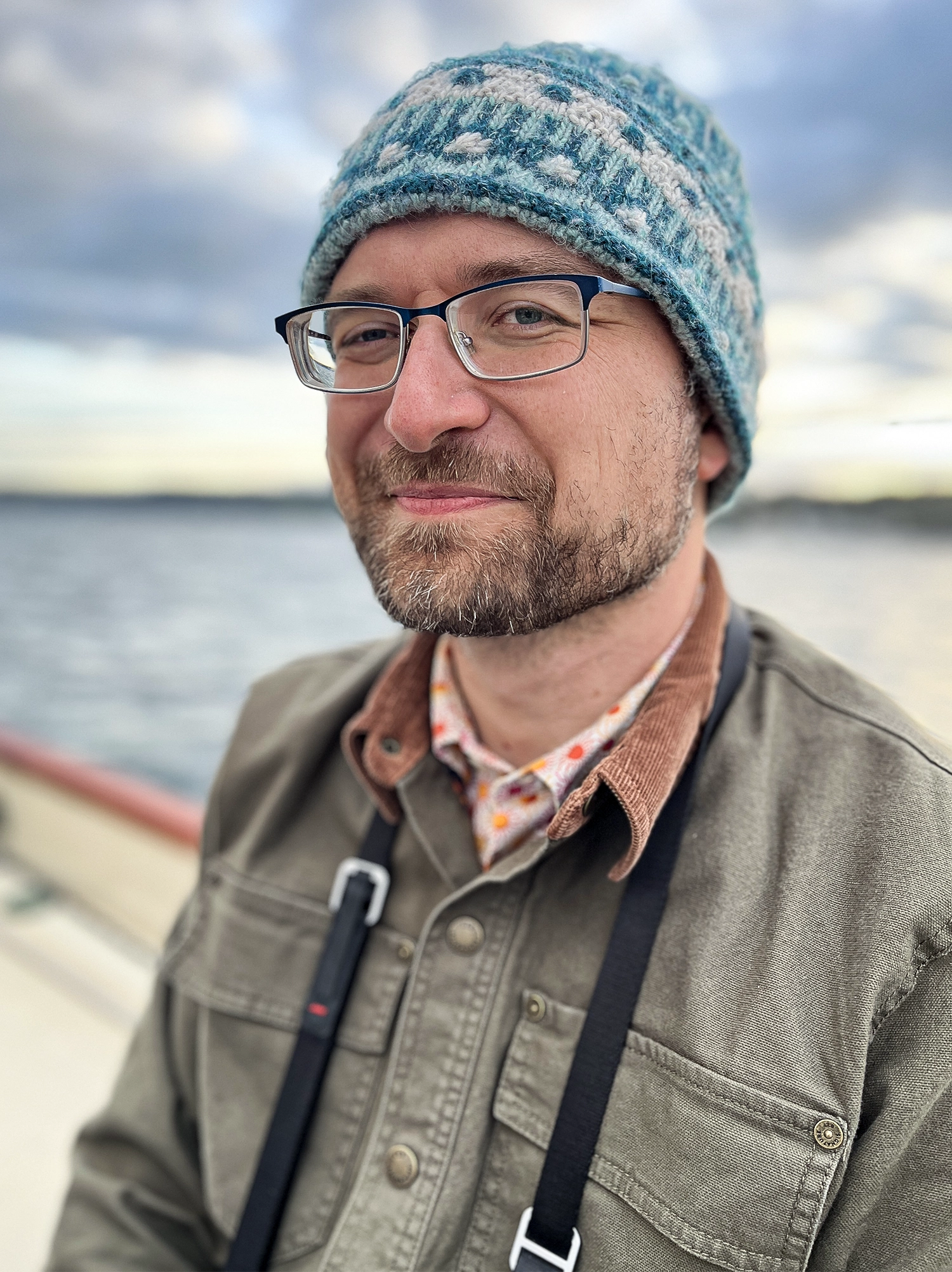 A man with glasses and a blue beanie