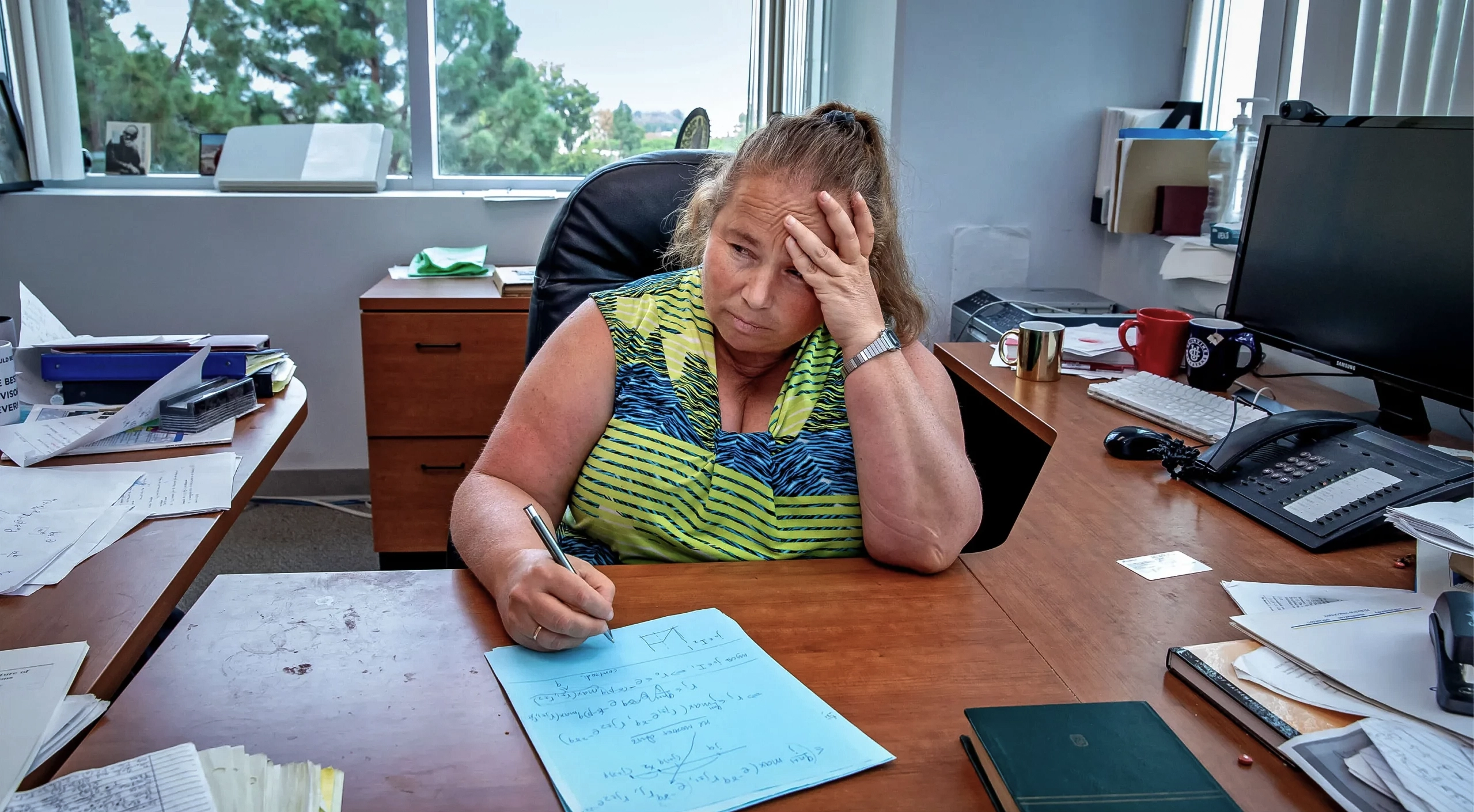 Blond woman in a green-and-blue shirt.