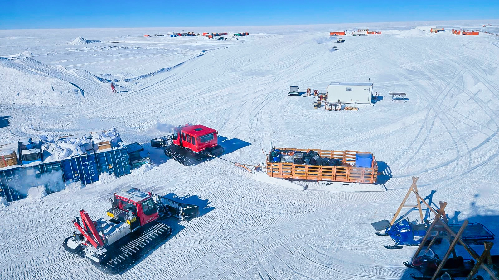 A couple of vehicles and storage crates on the icy drilling site Little Dome C.