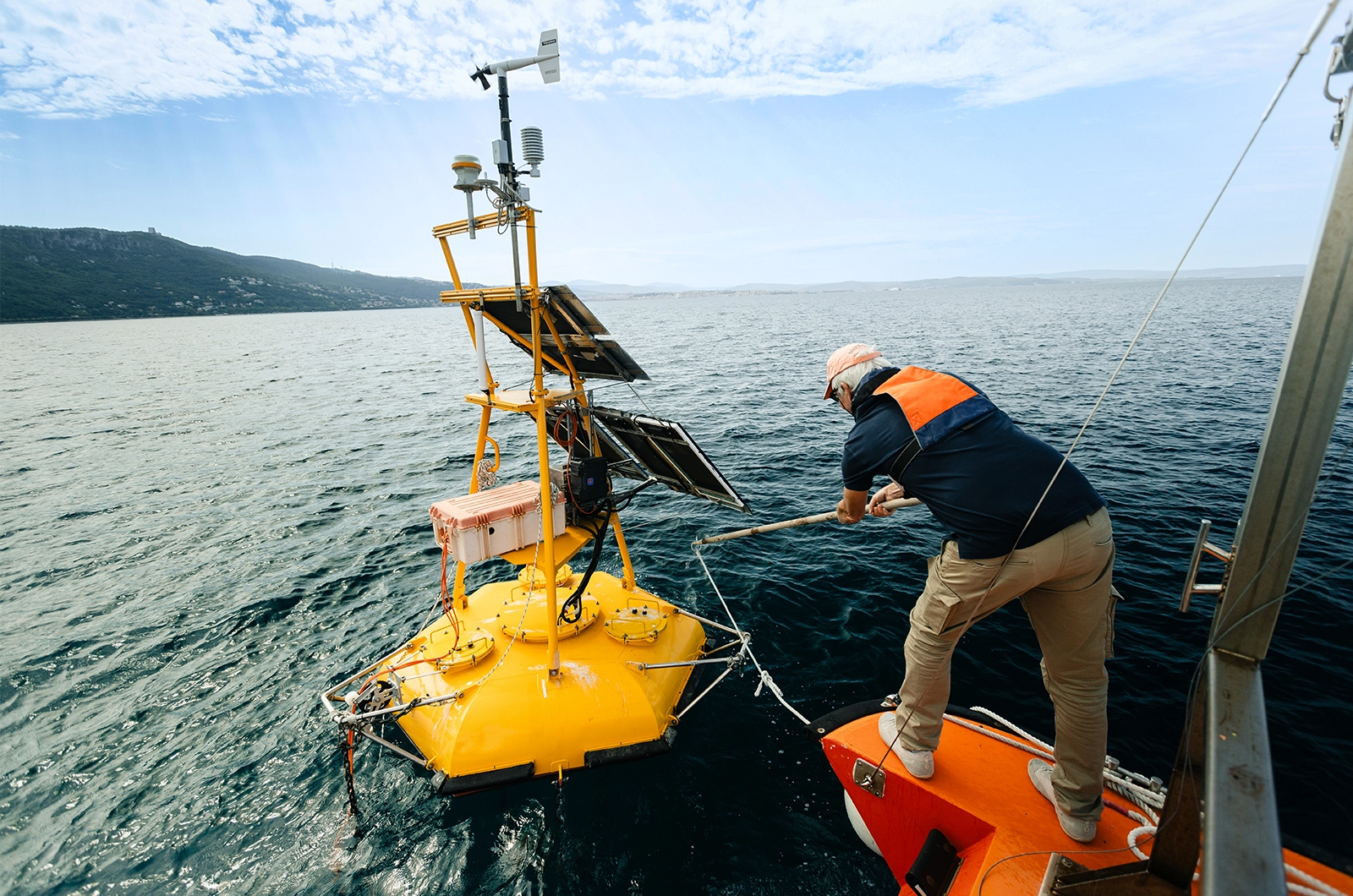 A scientist catches a buoy in the water.
