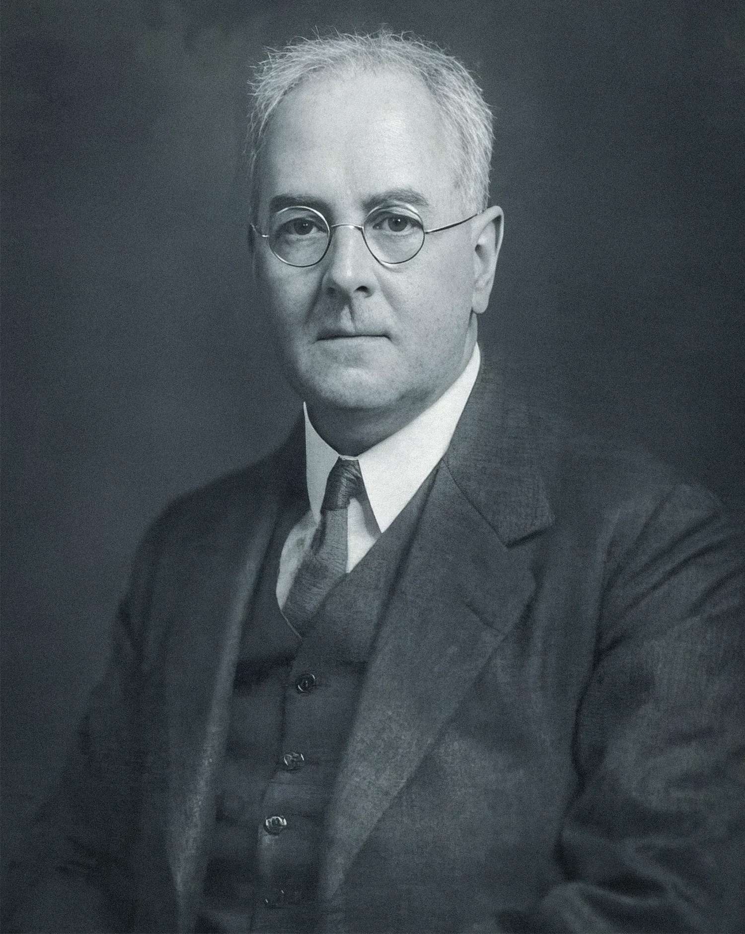 A black-and-white portrait of a man in a suit.