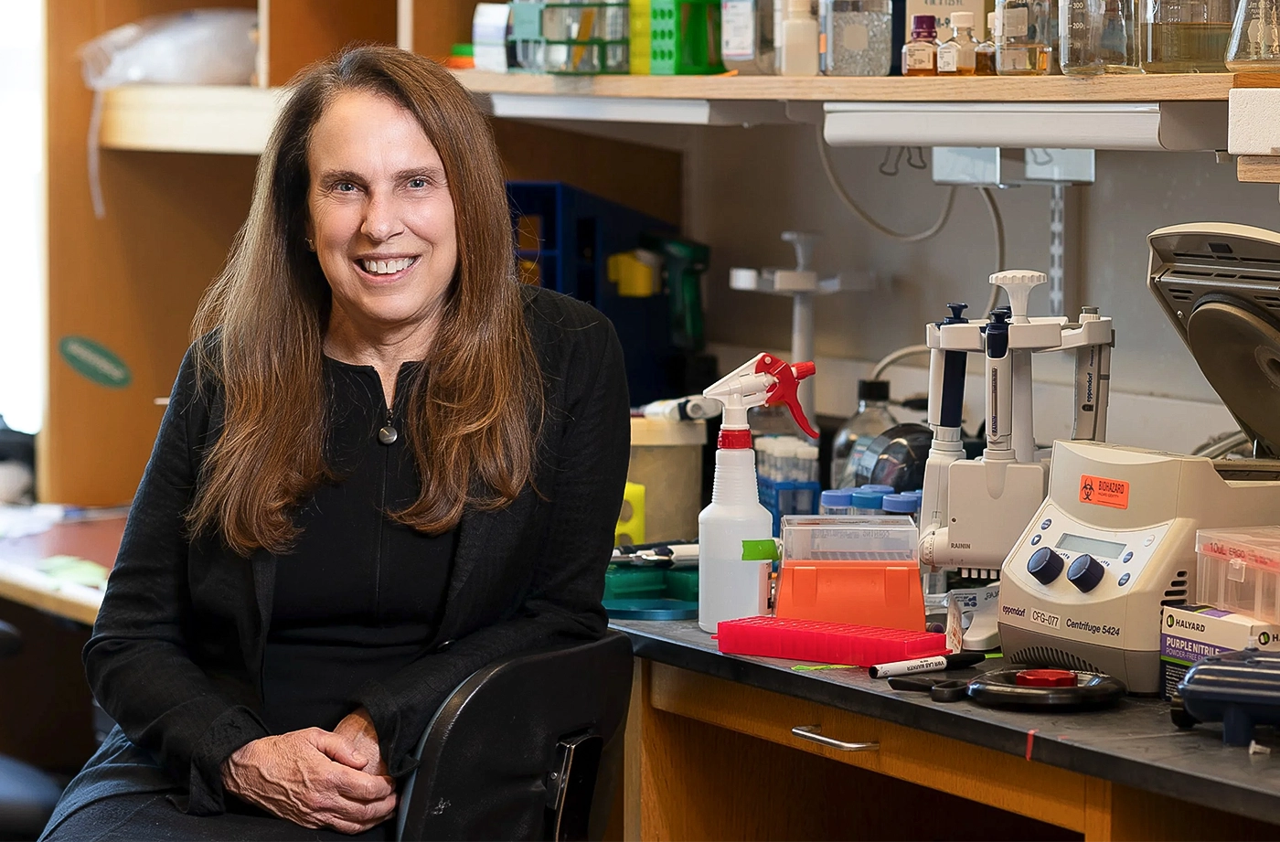 A smiling woman in a lab setting