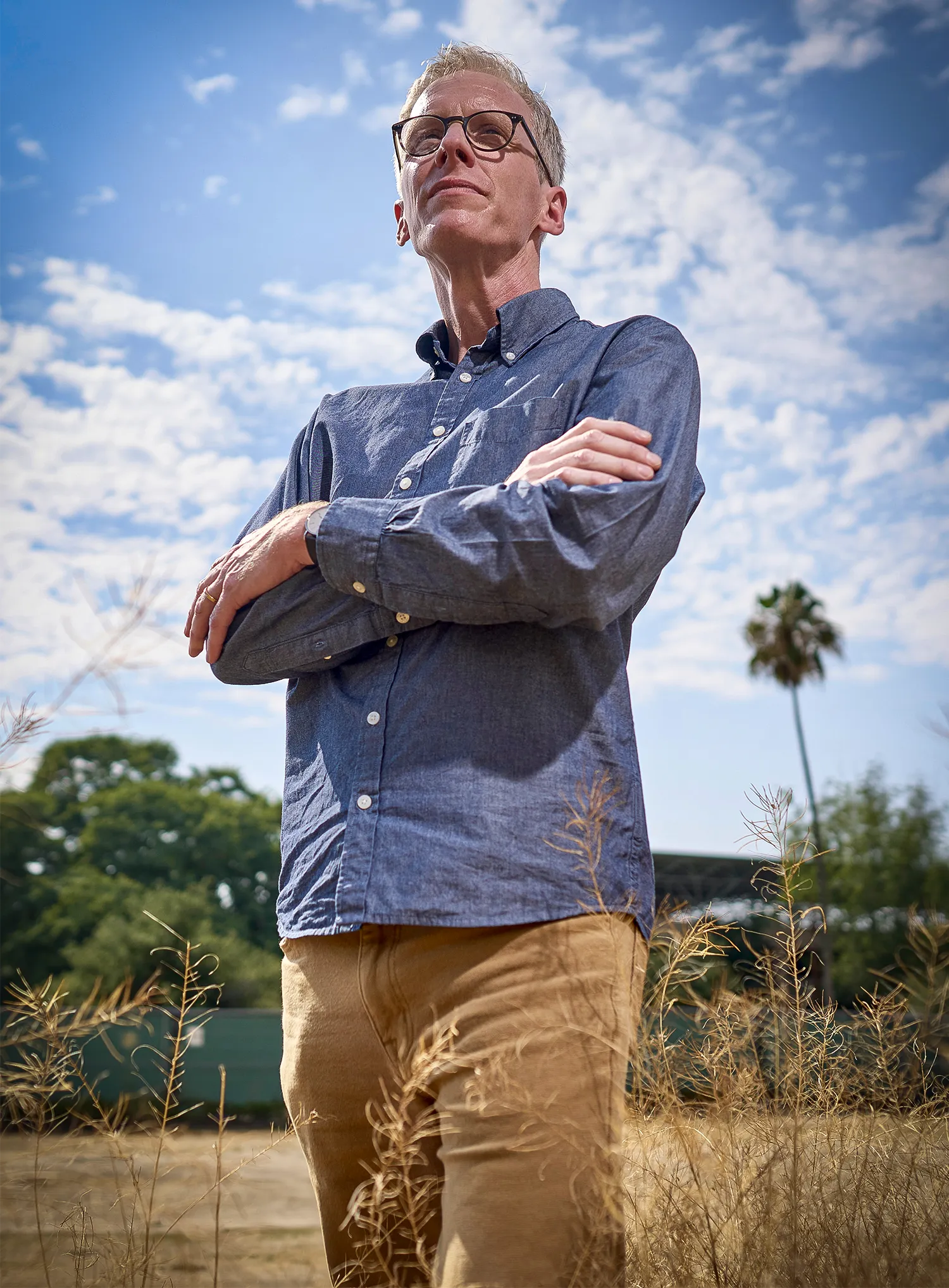 A blond man in a blue shirt looks down at the camera from above.