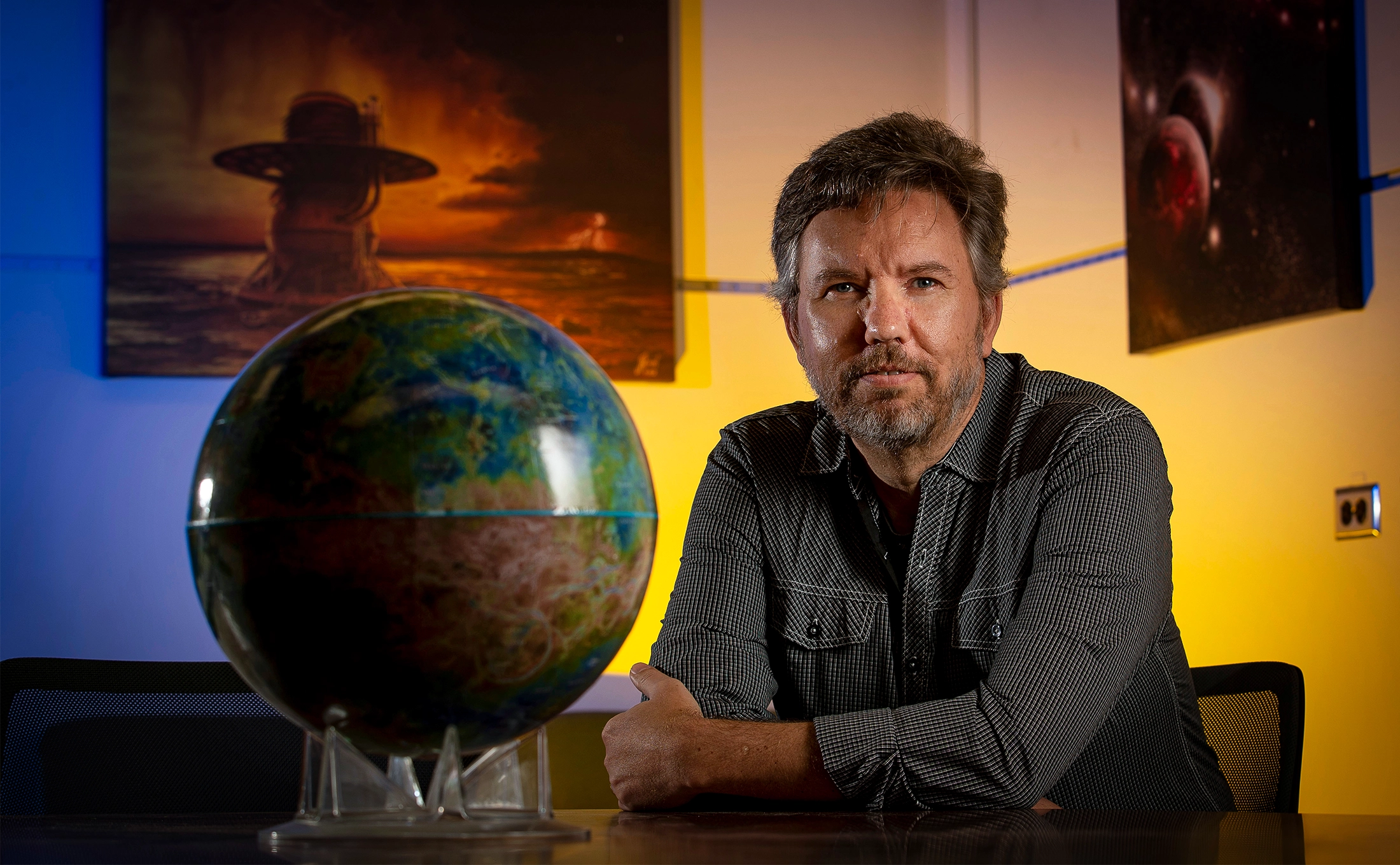 A man sitting next to a globe