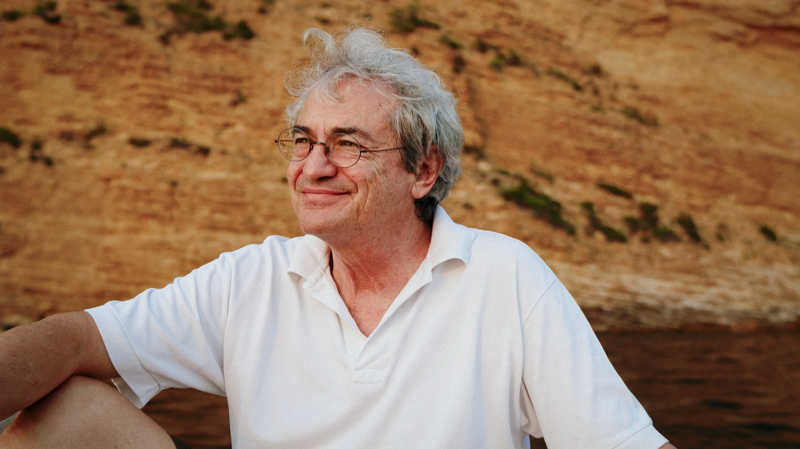 A man with glasses smiling