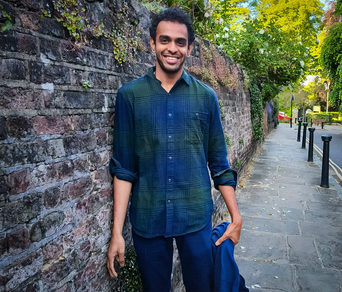 A smiling man standing on the sidewalk