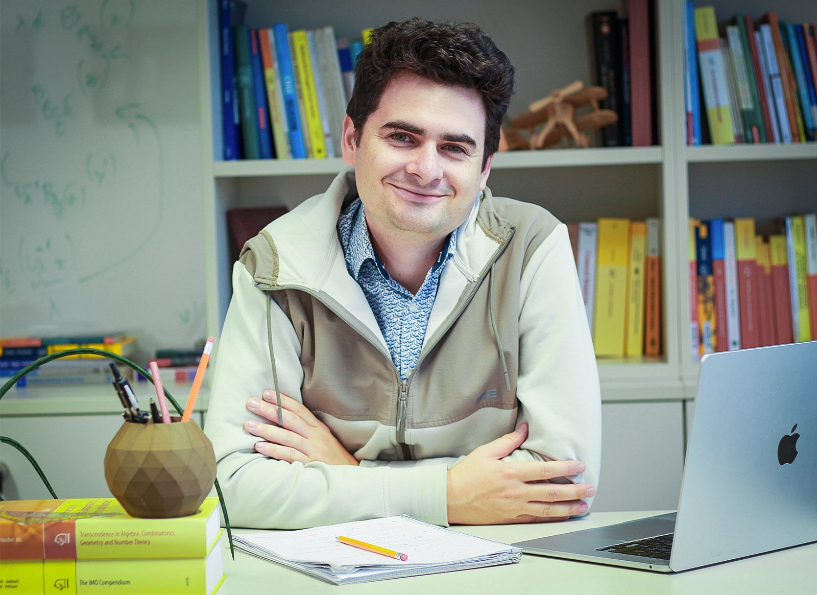 A smiling man sitting at a desk