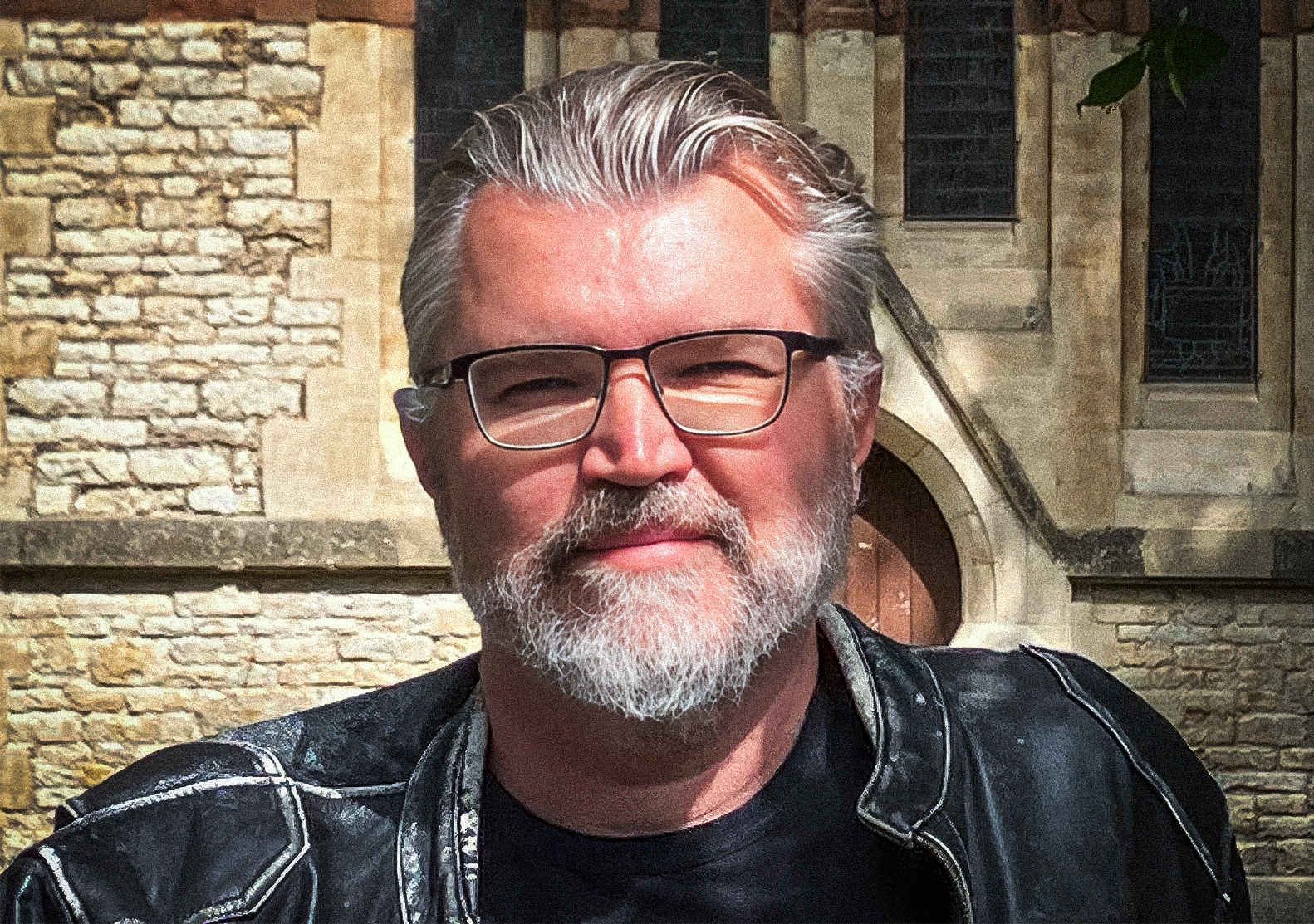 Portrait of a man with glasses and a gray beard.