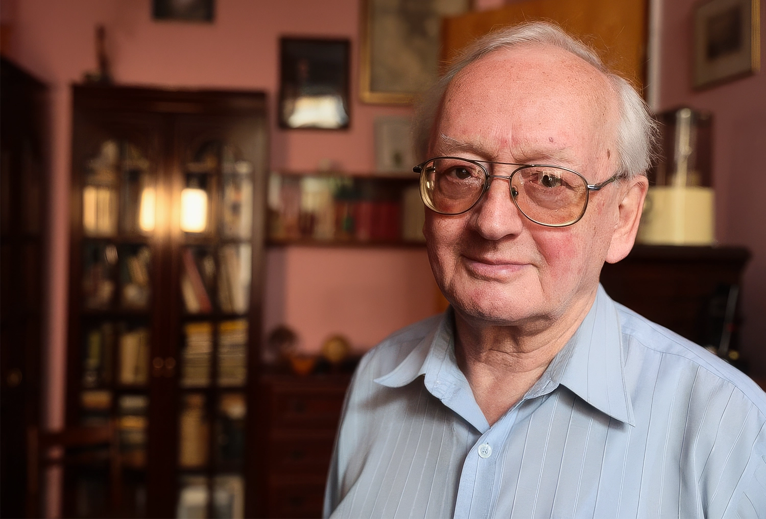 Portrait of a man with gray hair and large eyeglasses.