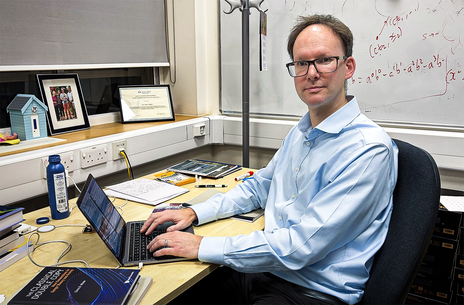 A pair of photos of identical-looking men in their offices.