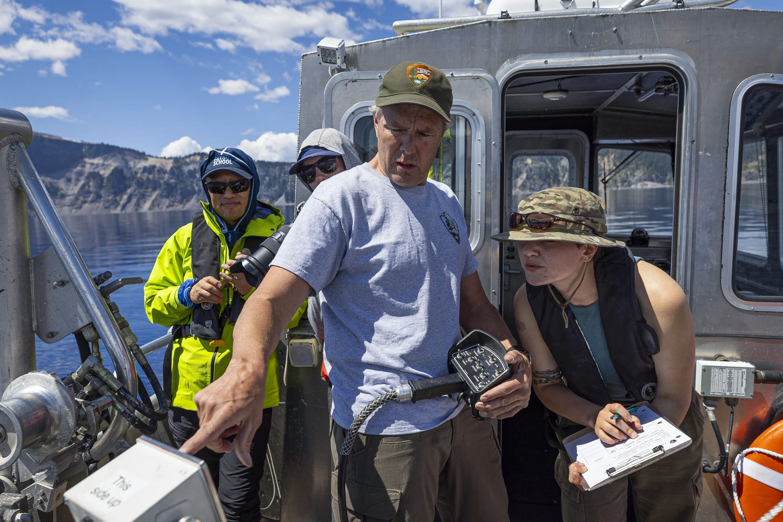 Scott Girdner (left) and Taryn Weller use equipment on a boat deck.