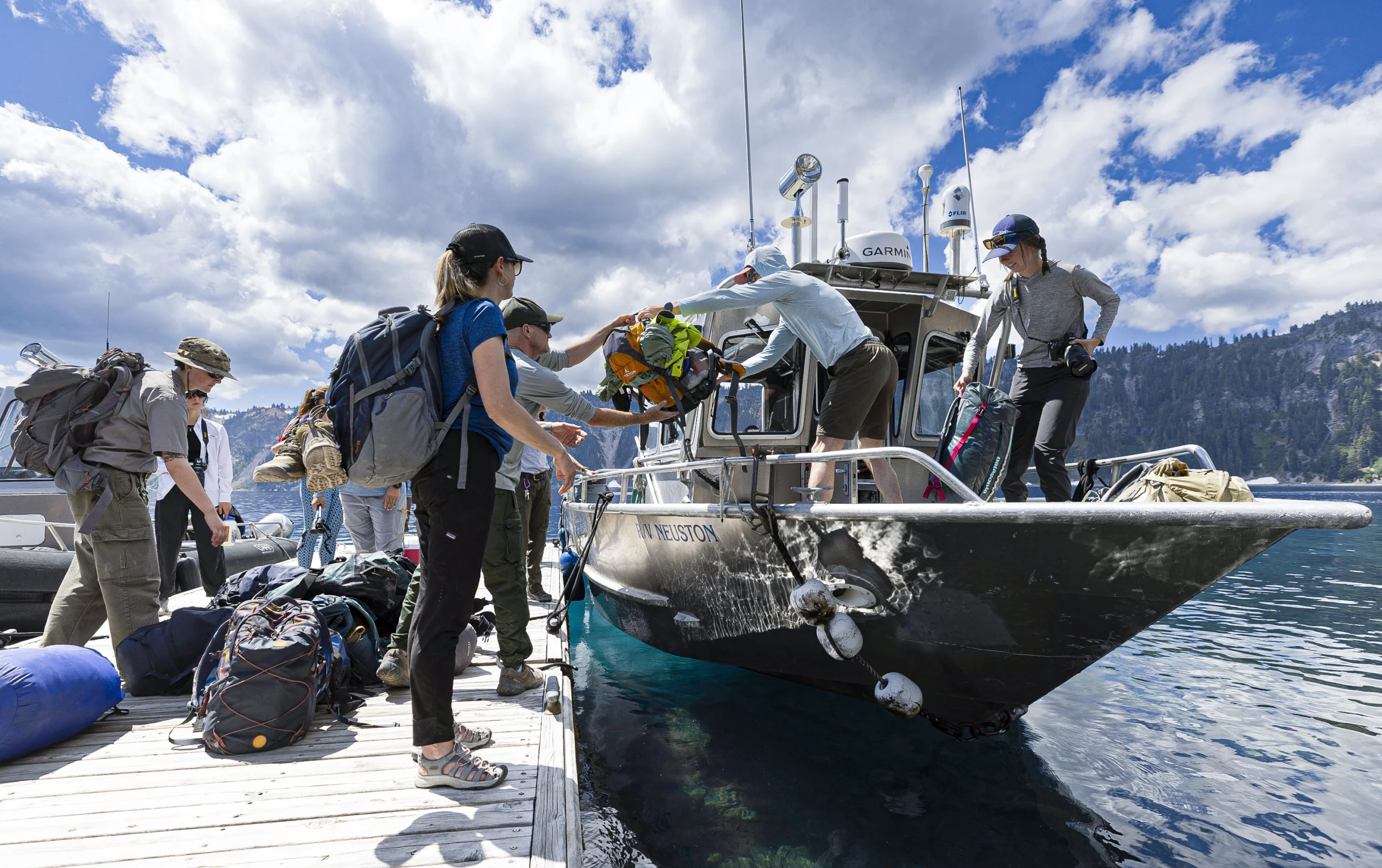 Researchers unload luggage and equipment from a boat.