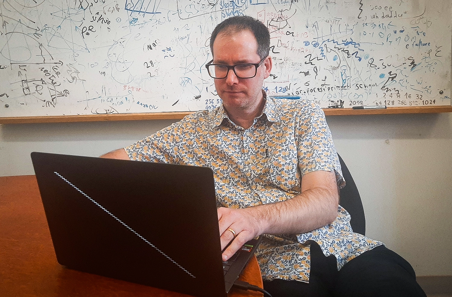 A pair of photos of identical-looking men in their offices.