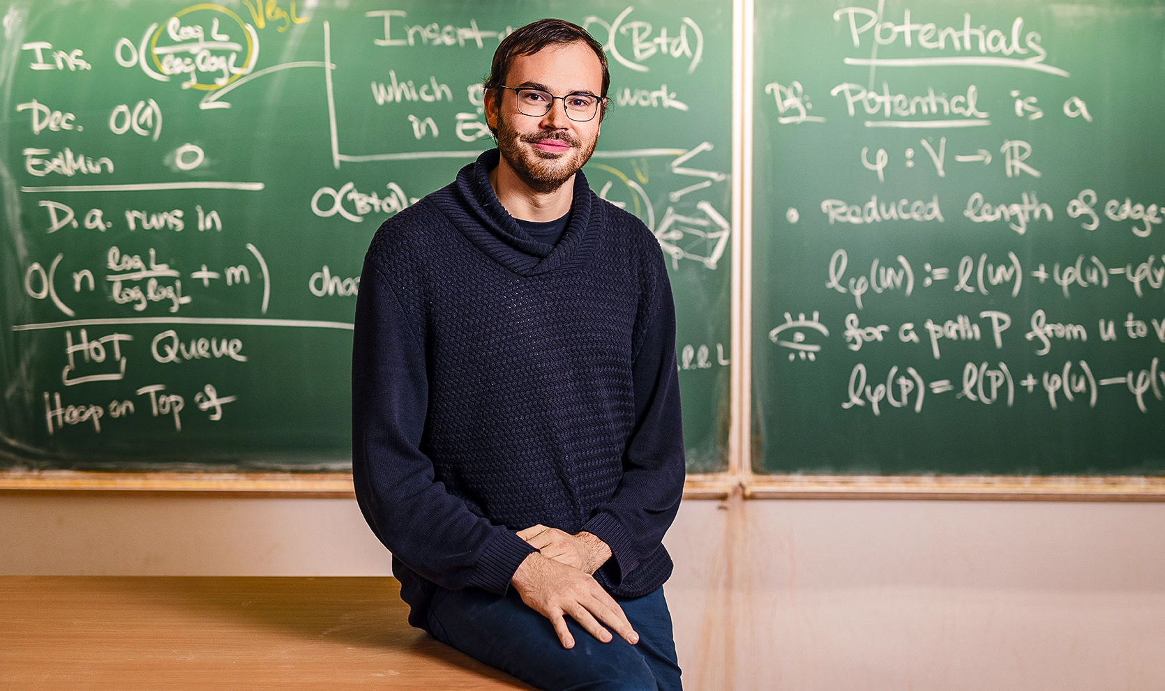 A man sitting in front of a chalkboard