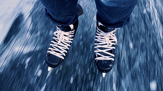 A close-up video of ice skates skating on ice.