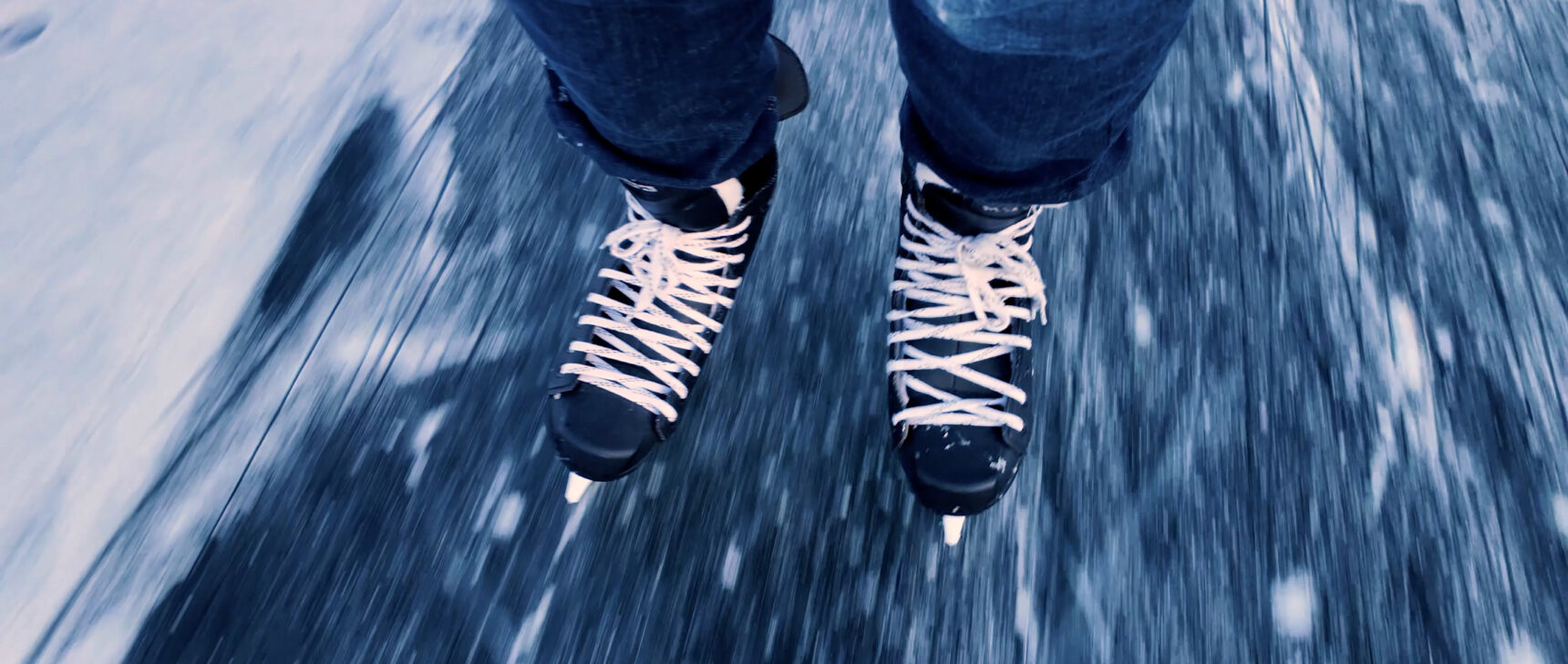 A close-up video of ice skates skating on ice