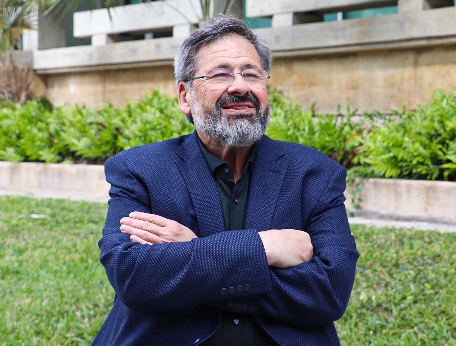 Bearded man in glasses and a dark blue suit.