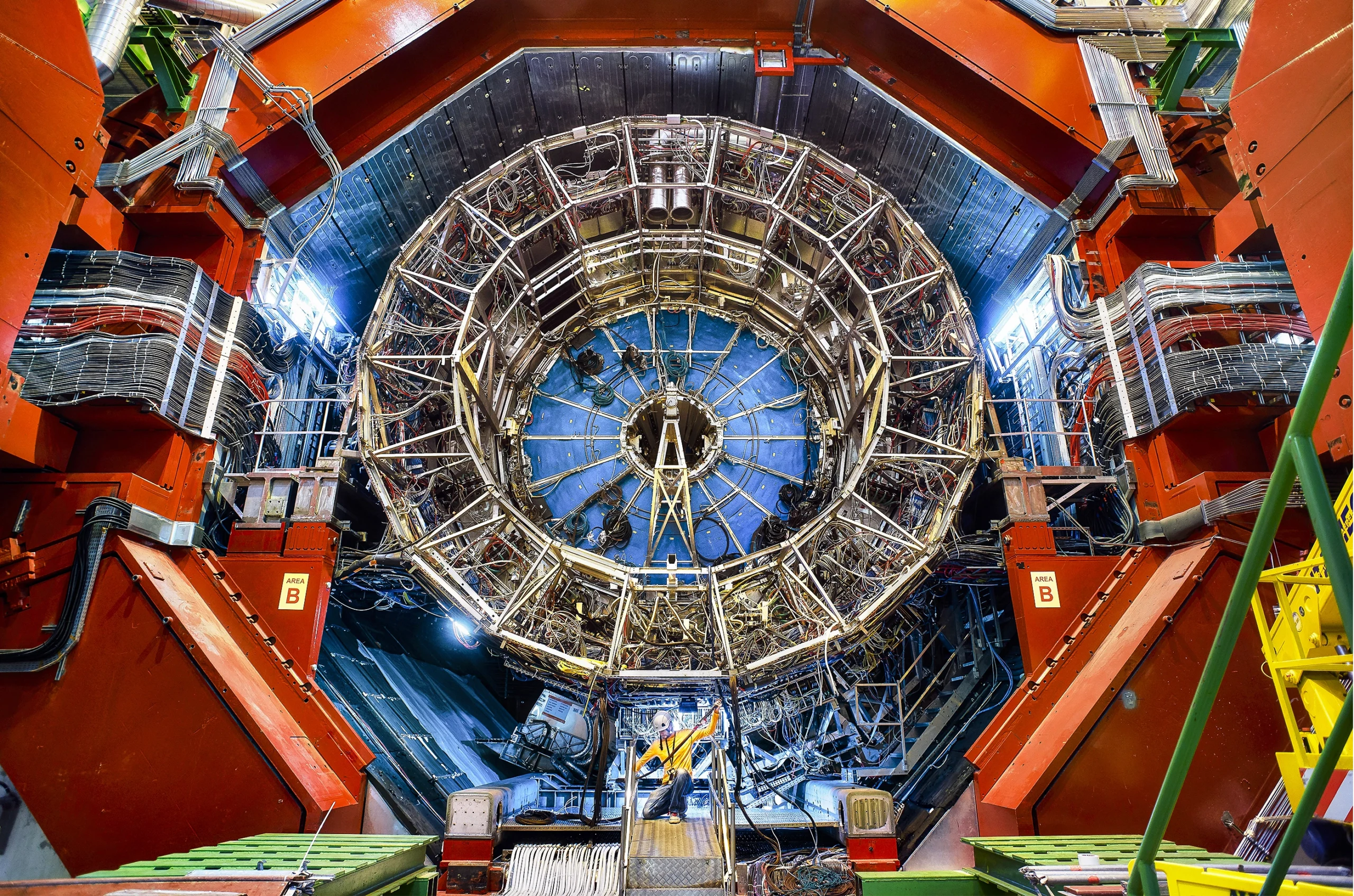 A large scientific instrument with radial symmetry, with a technician at the bottom.