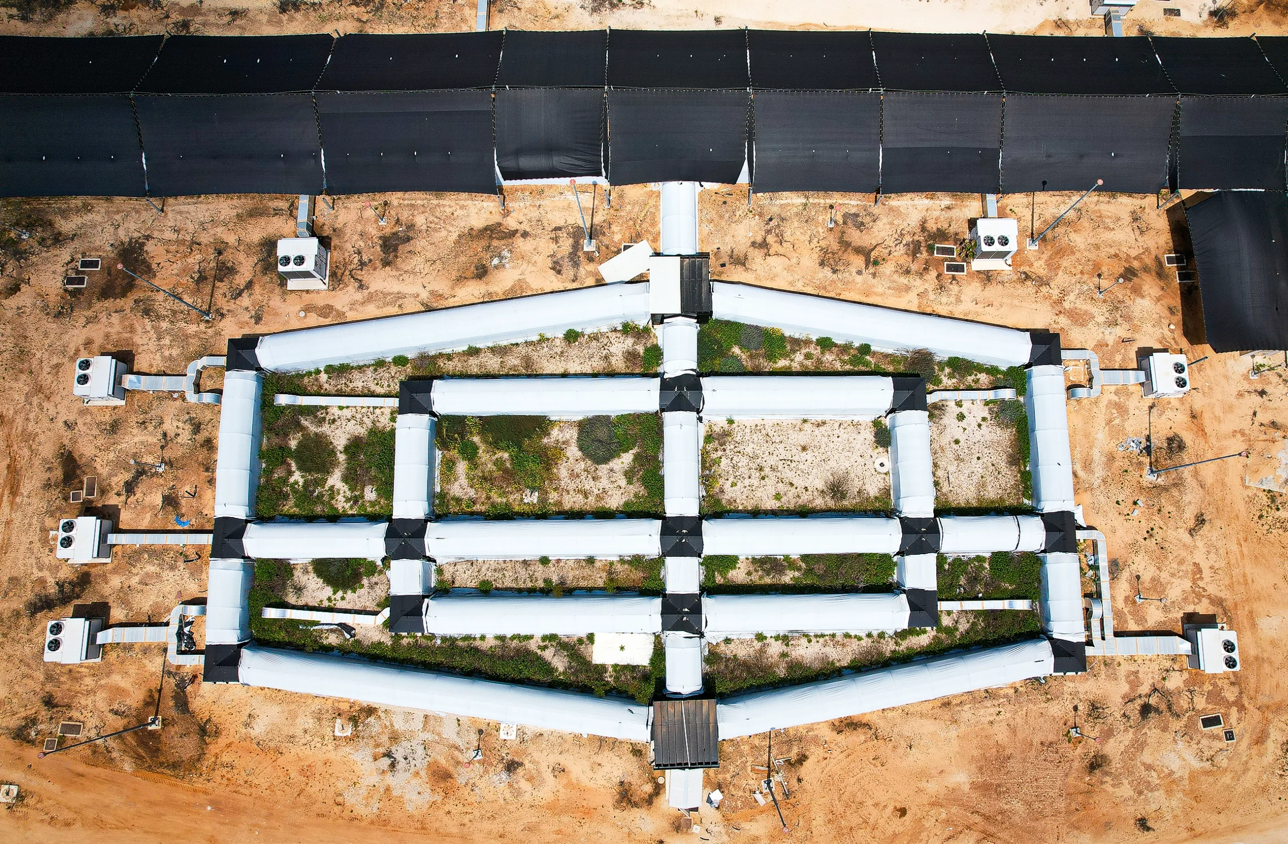 An overhead photo shows a complex tunnel system constructed over the desert.