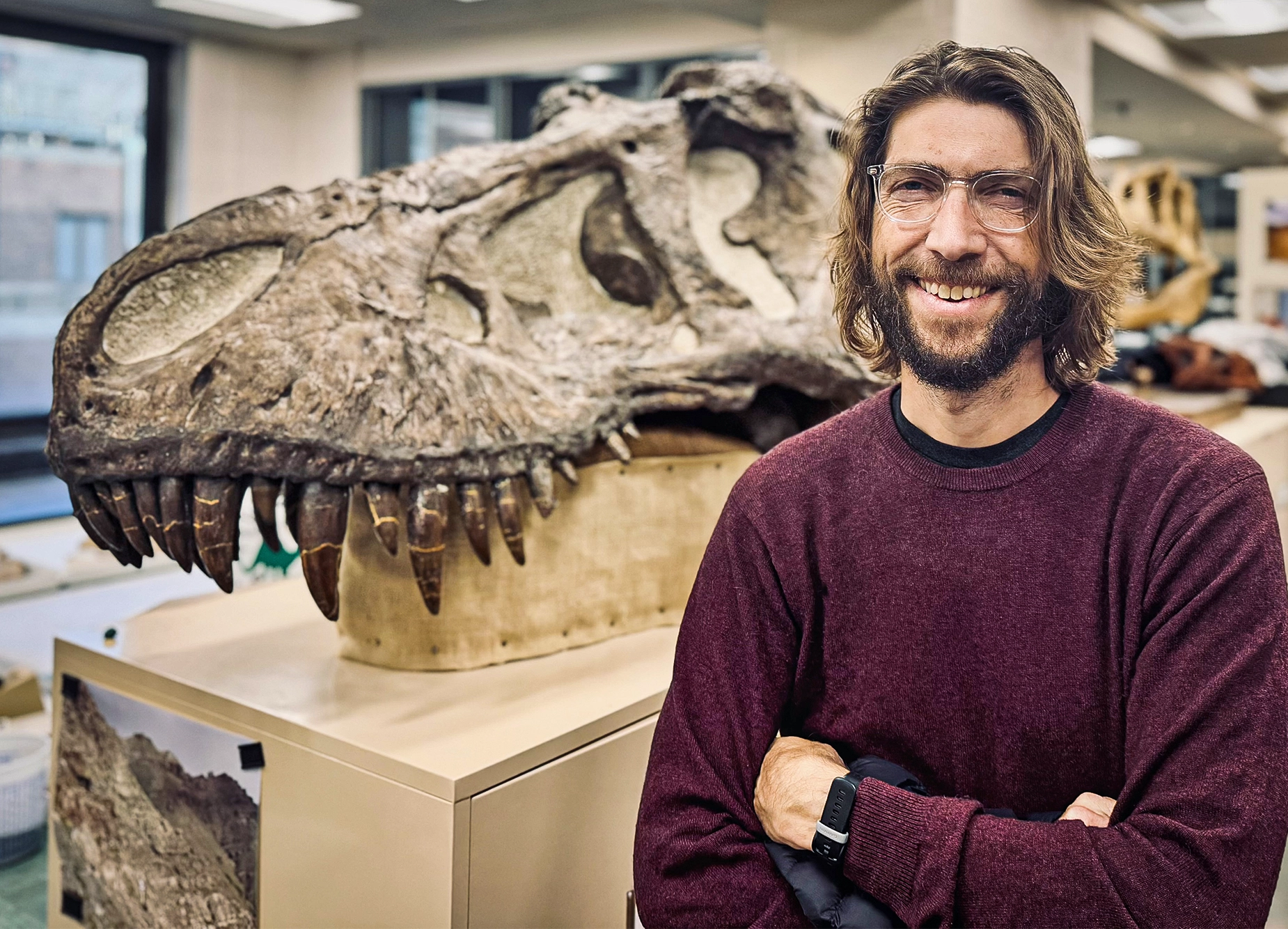 Liam Holt poses in front of a dinosaur skull.