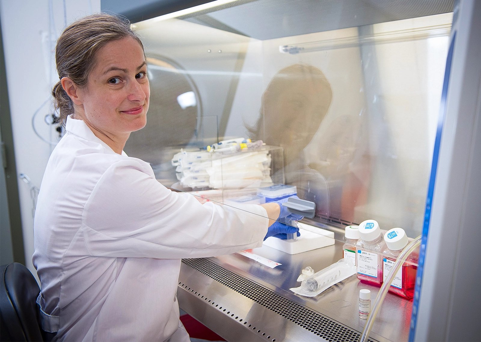 Claudia Doege sits at a fume hood in her lab.