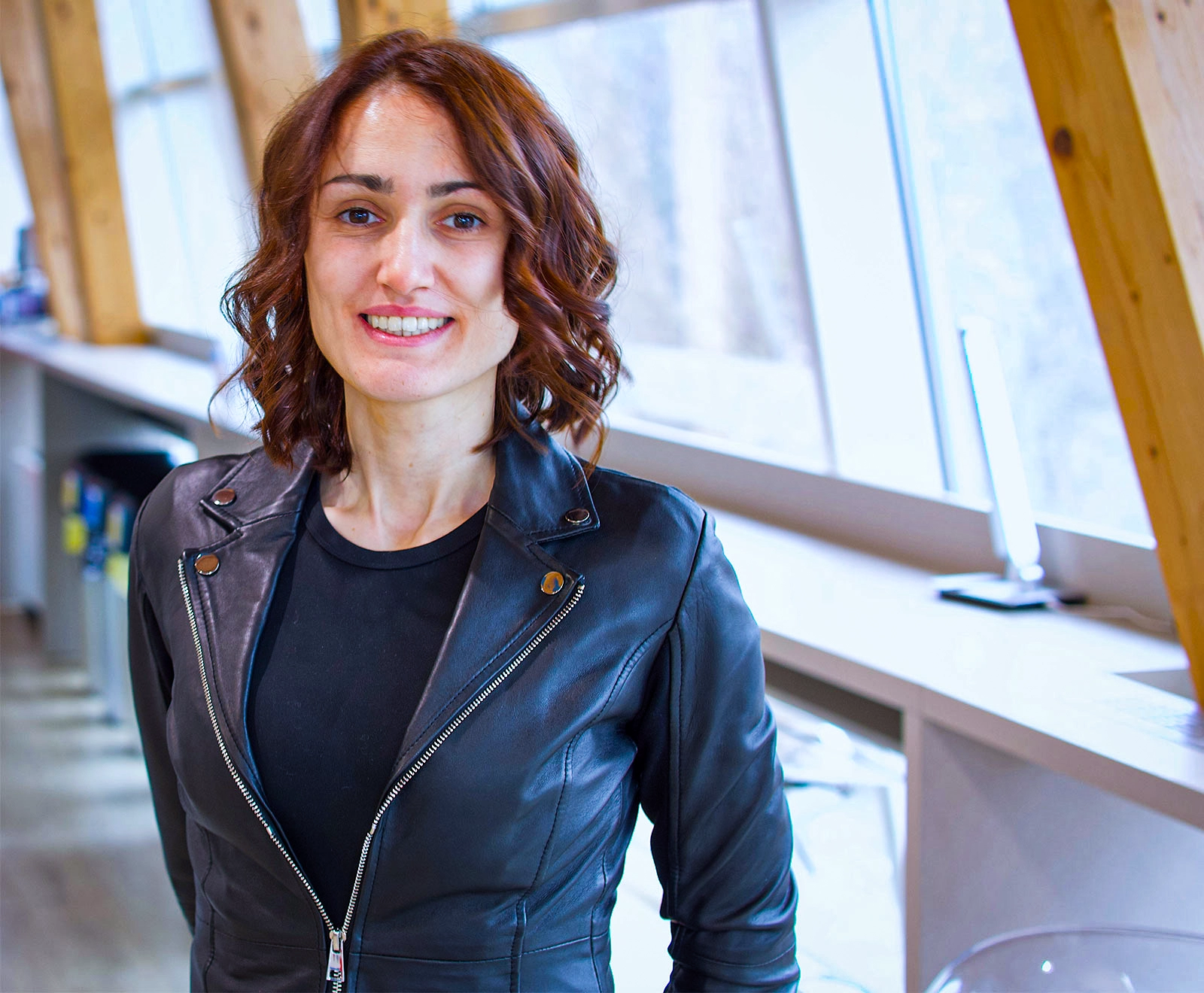 Woman smiling in a black leather jacket.