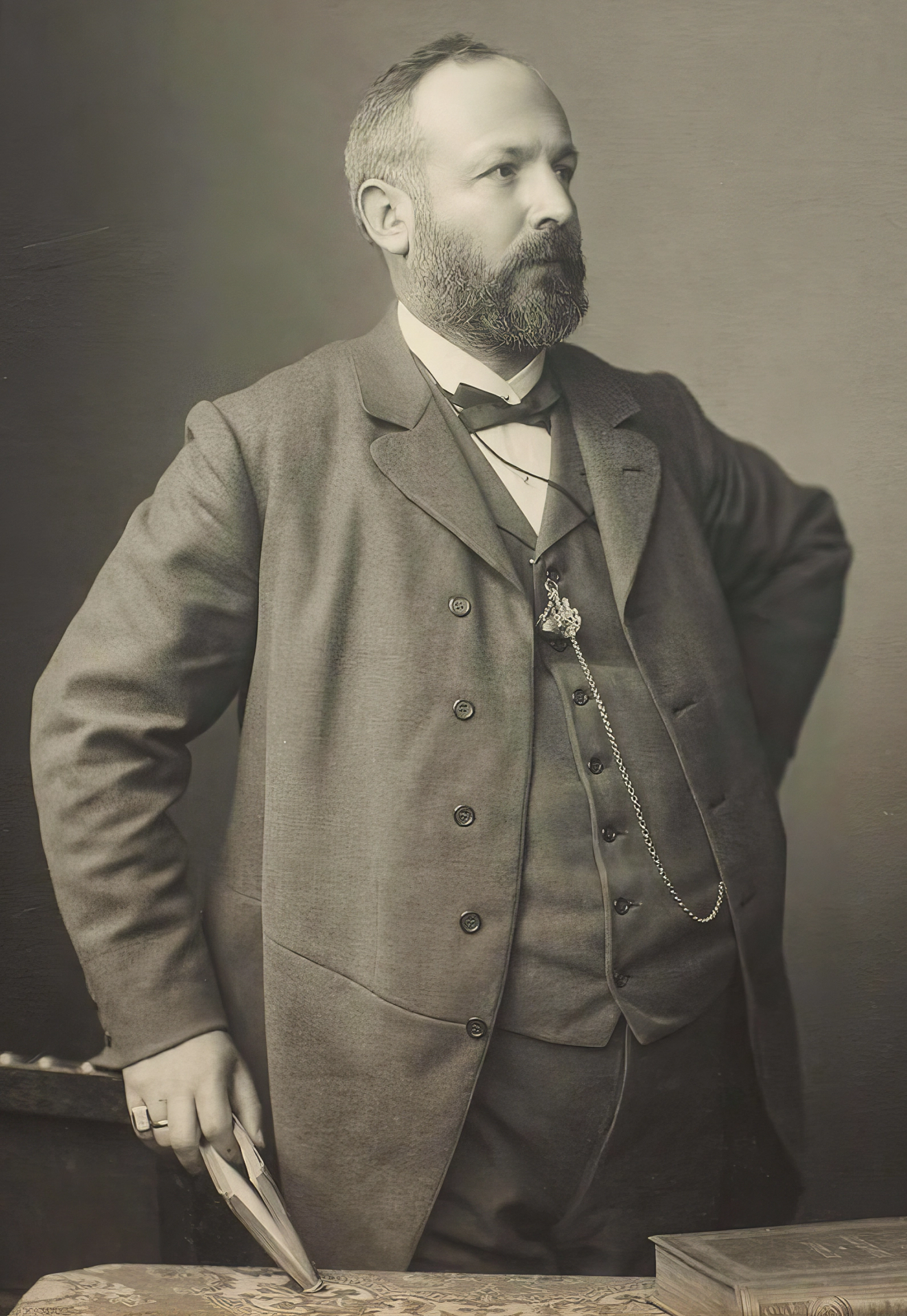 Black-and-white photo of a man standing confidently in a suit.