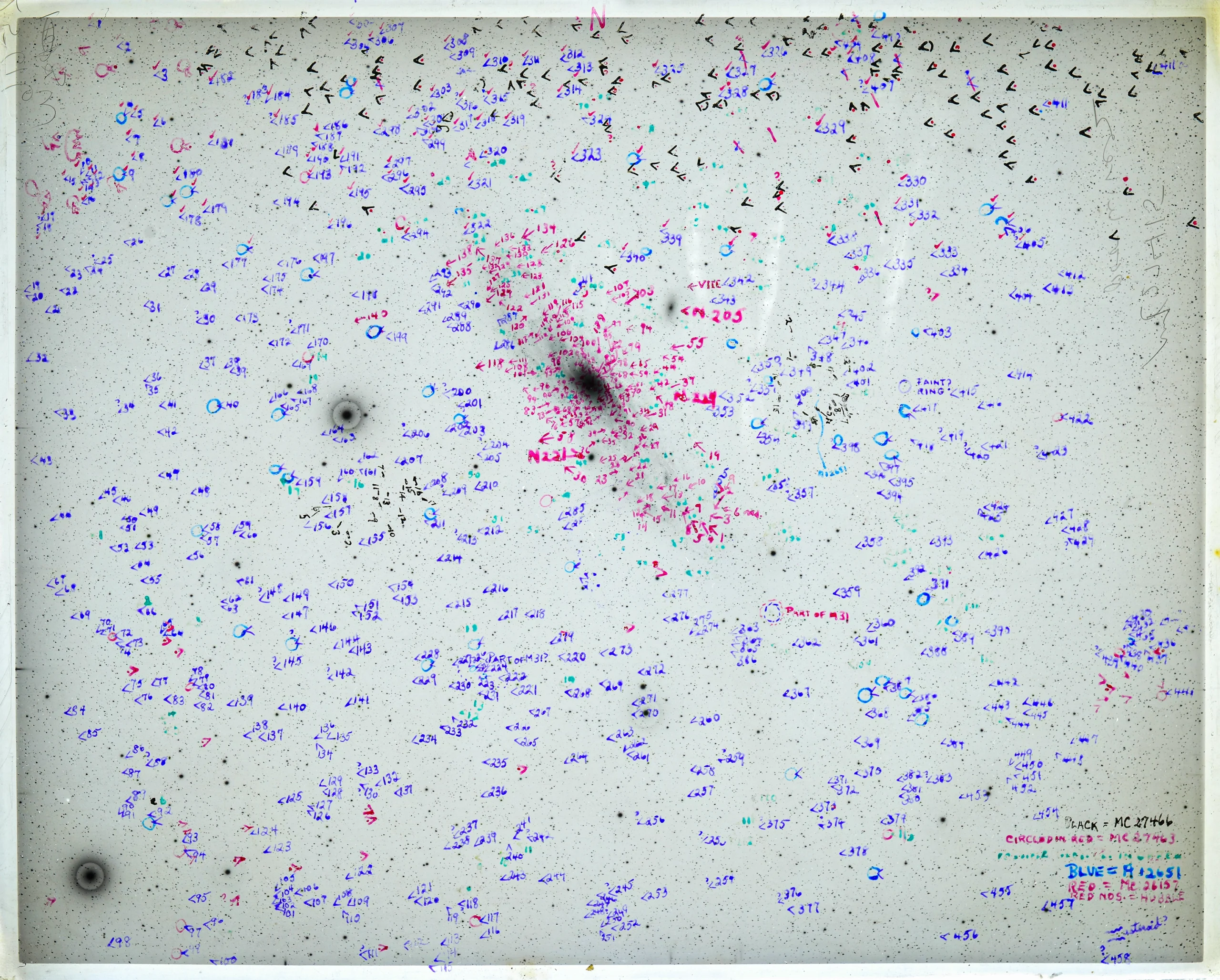 An astronomical photo negative of a galaxy is heavily marked in purple and red marker.