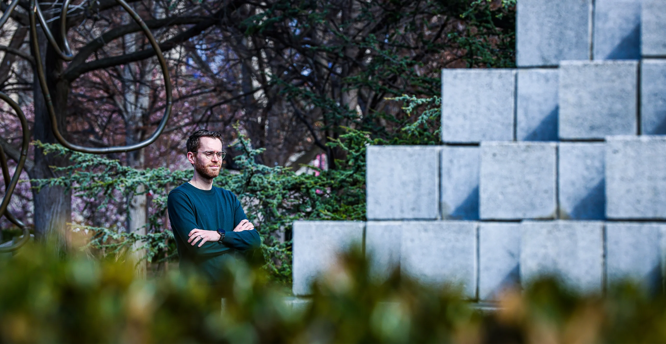 Man standing next to a sculpture of concrete blocks.