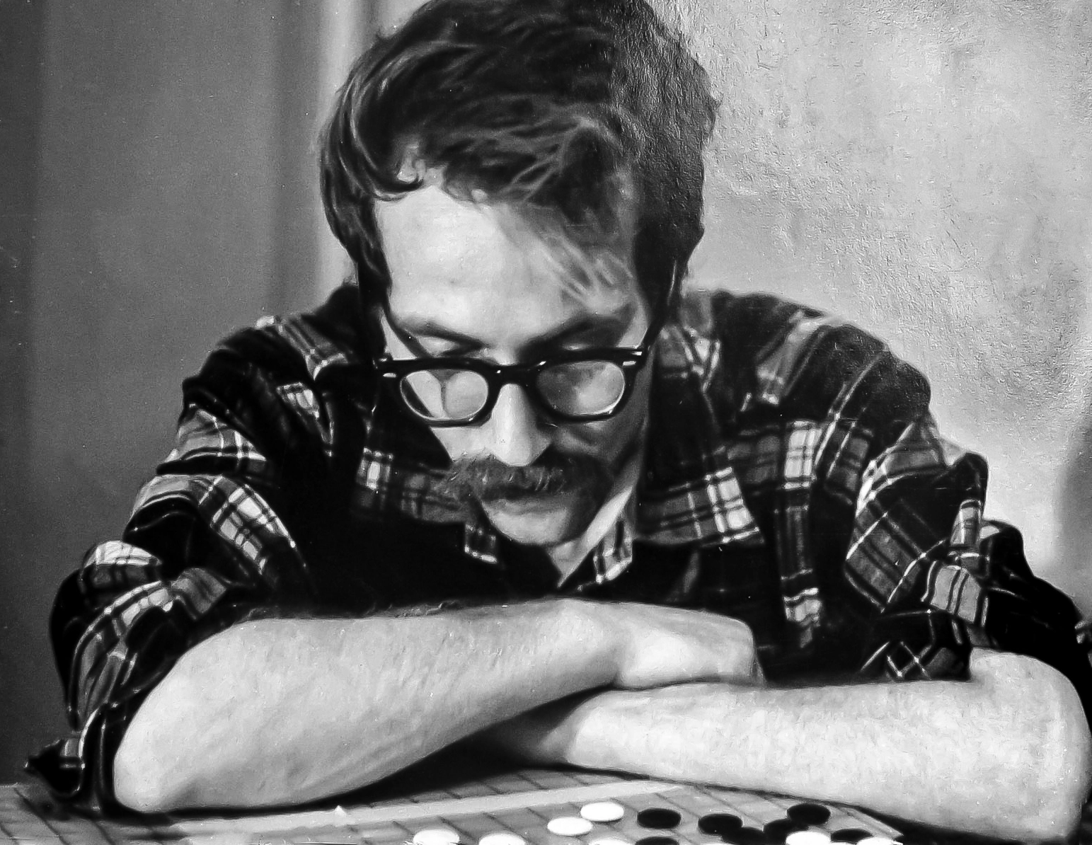 A black and white photo of a man playing Go.