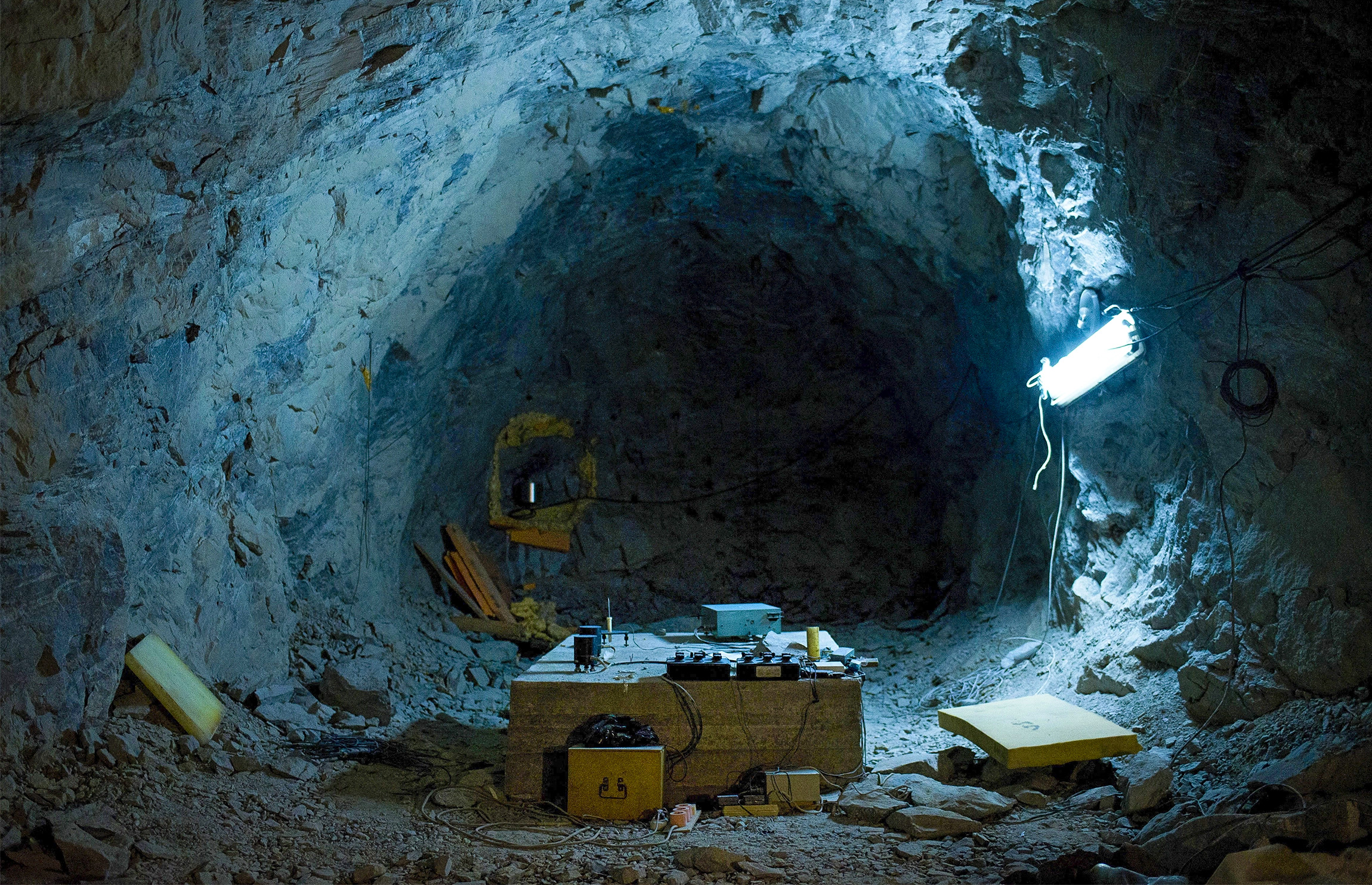 Equipment lies on the ground in the center of a blue cave.