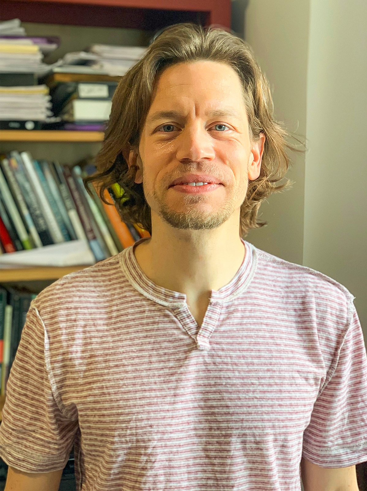 Man in front of a bookshelf.