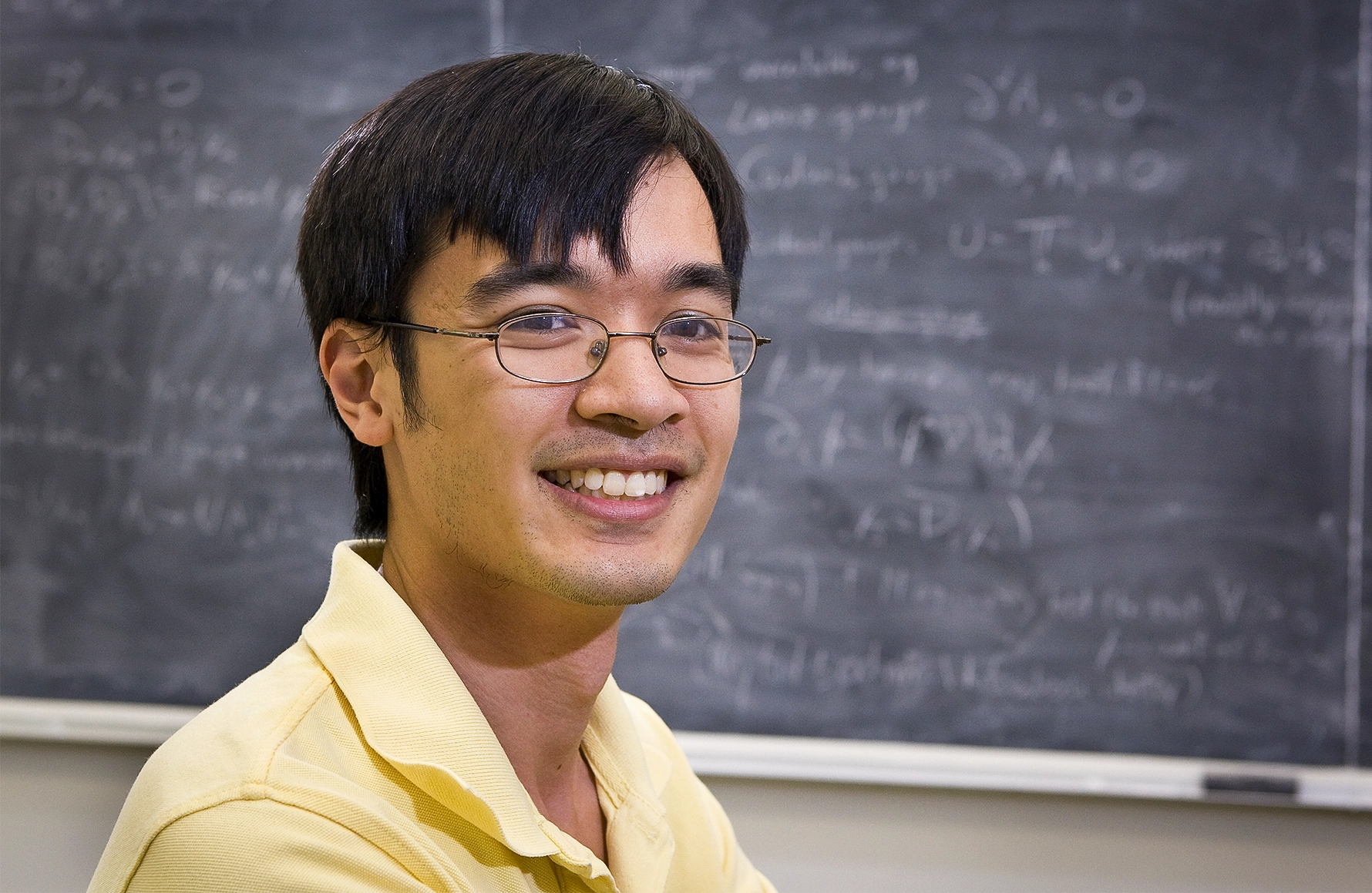 Man in yellow shirt wearing glasses.