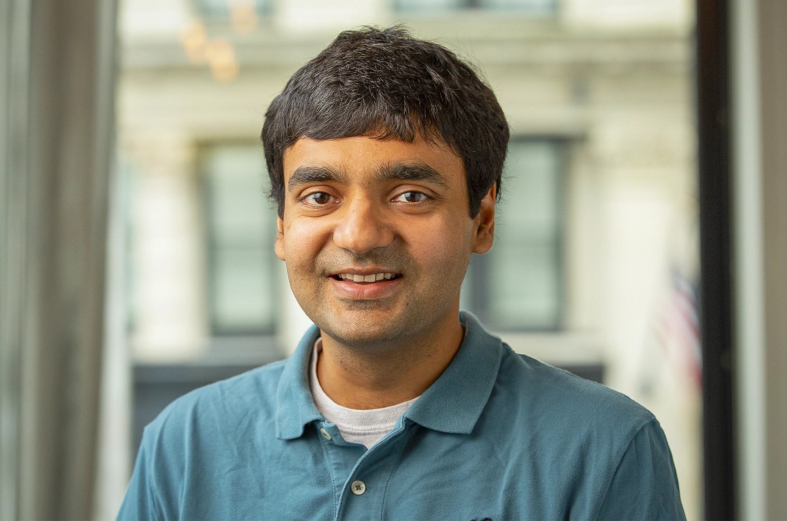 Man smiling in a teal shirt.