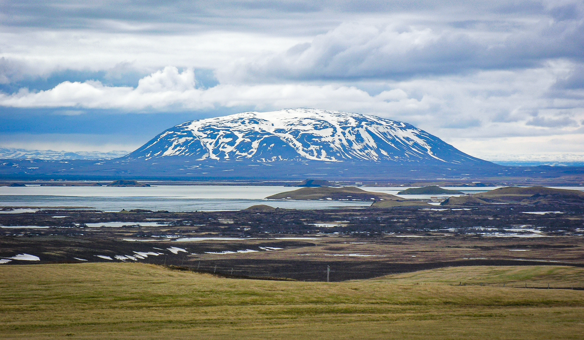 A landscape with a snowy mountain with a slightly rounded top.