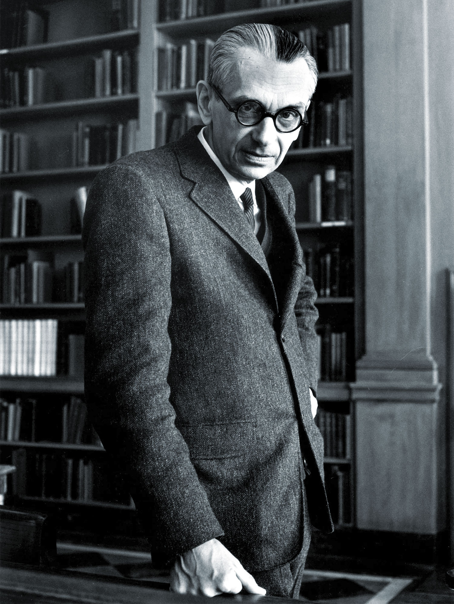 Black-and-white photo of a man wearing round glasses.