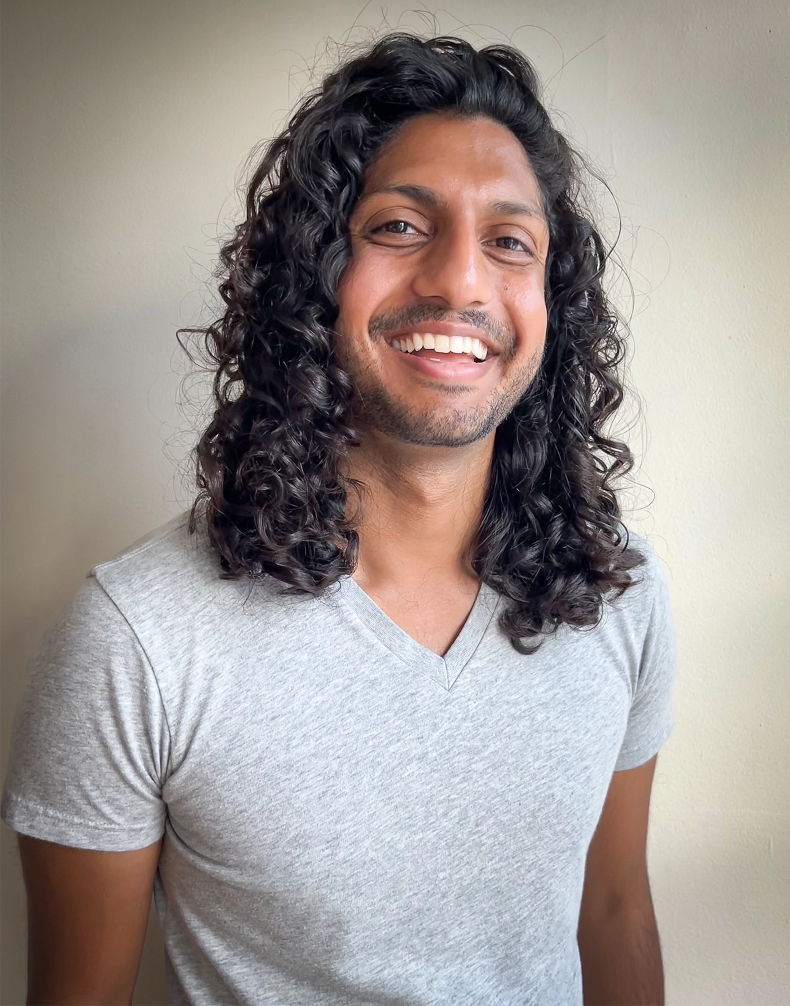 Smiling man with long hair.
